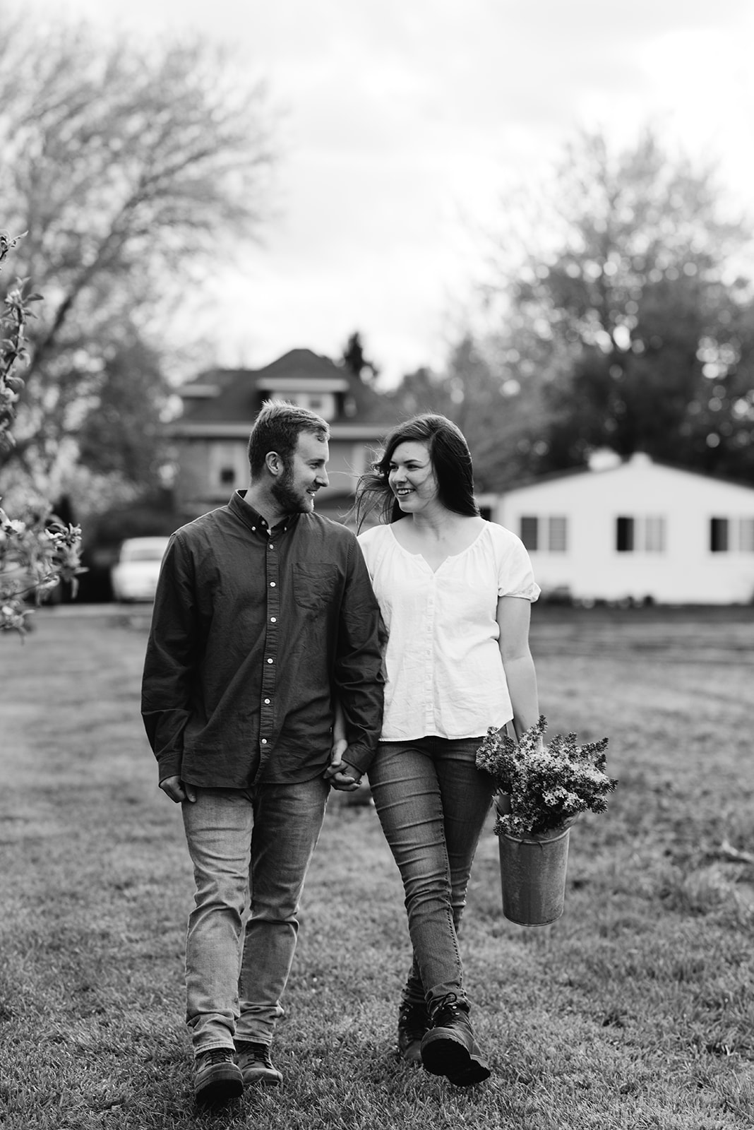 couple-walking-on-farm-with-flowers-wellman-iowa-engagement-session