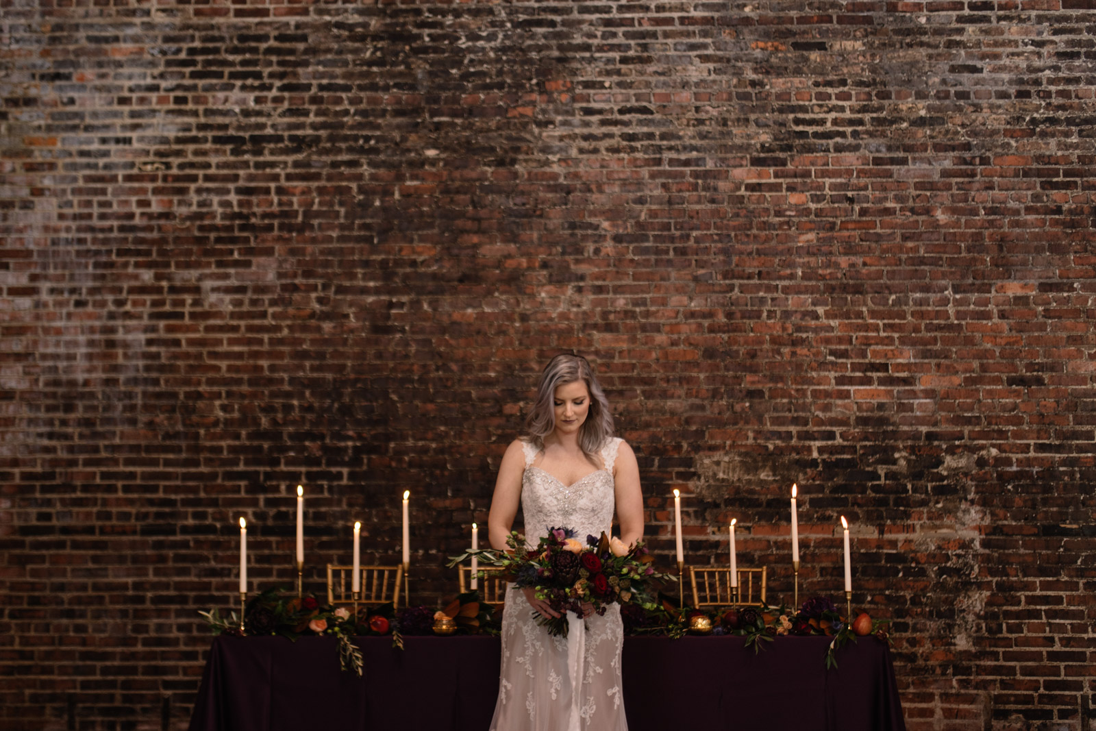 bride in front of head table by brick wall at cedar rapids wedding venue