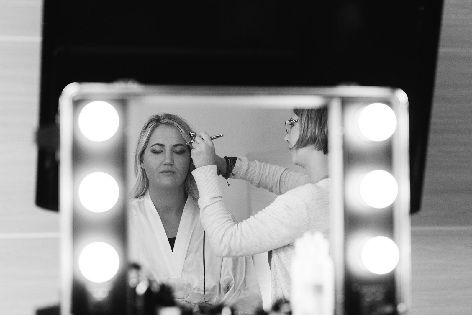 bride getting makeup done in mirror cedar rapids marriott