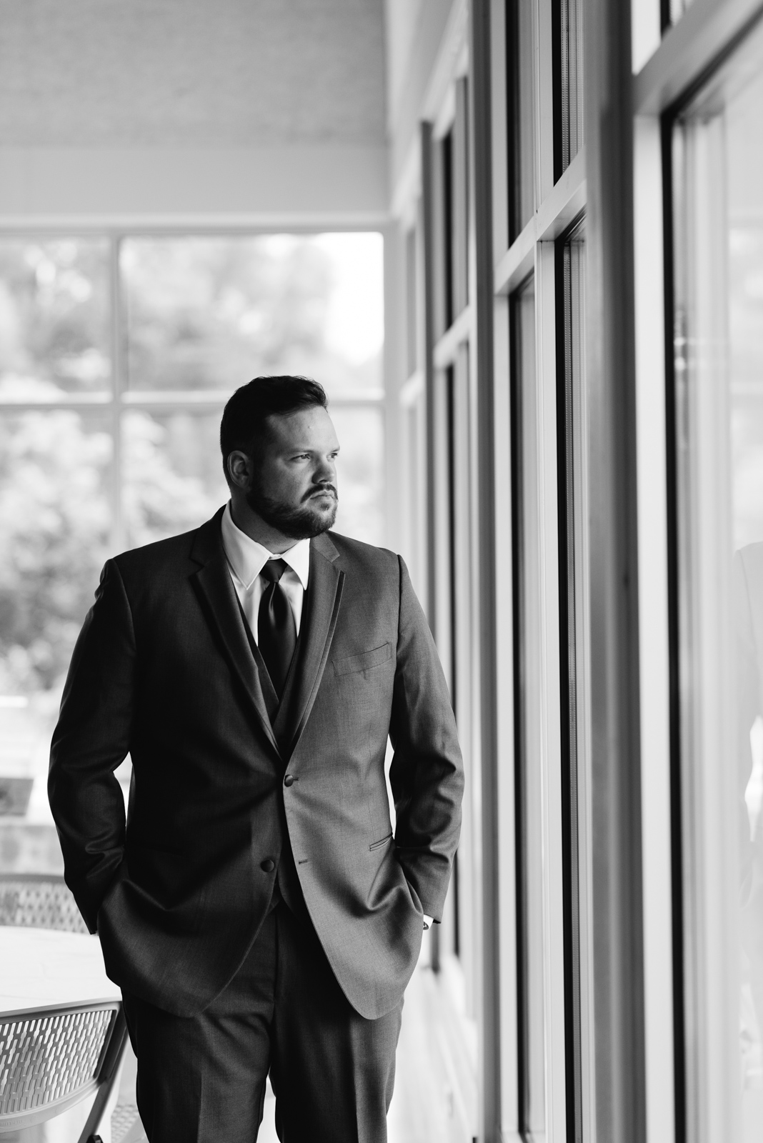 Groom standing in window cedar rapids wedding