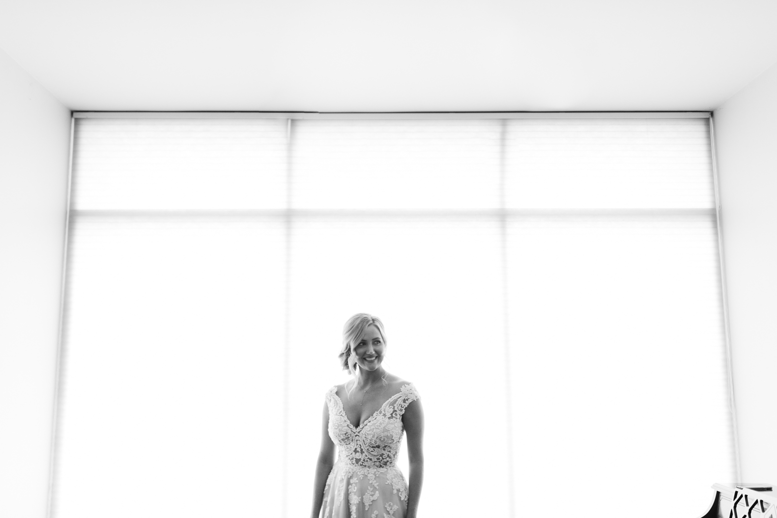 bride in front of large windows St. John XXIII Parish wedding