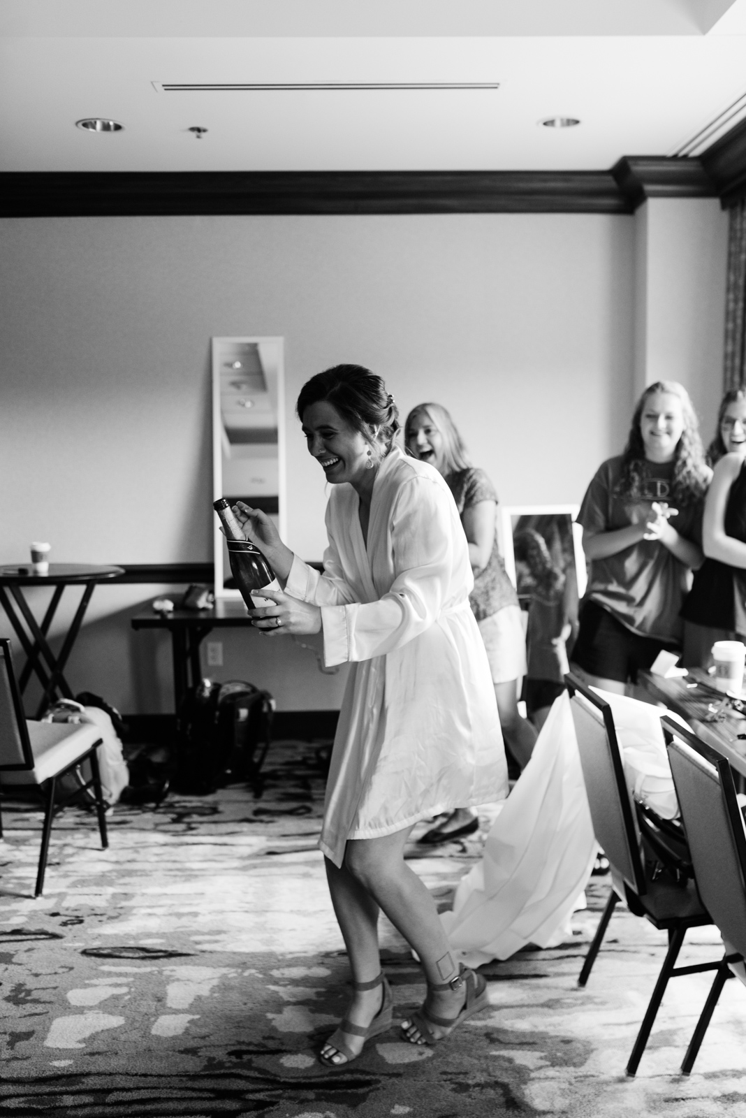 Bride popping champagne at Coralville Marriott Hotel Wedding 