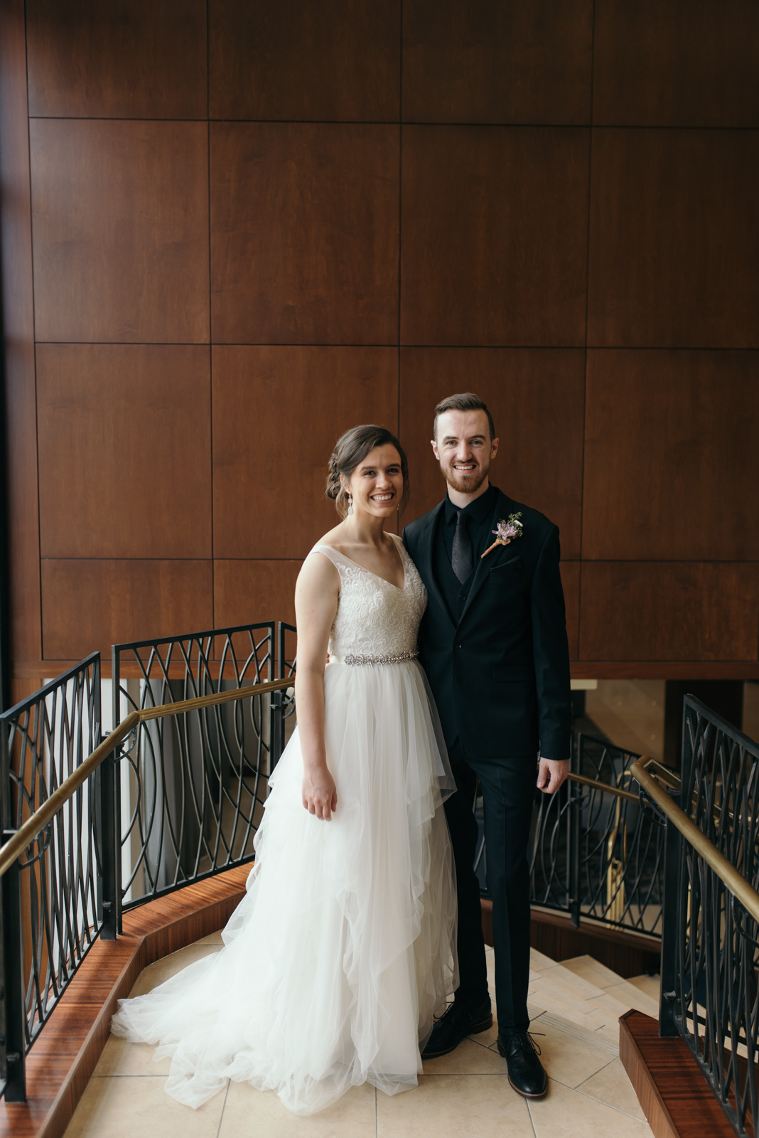 bride and groom on grand staircase at Coralville Marriott Hotel Wedding Venue