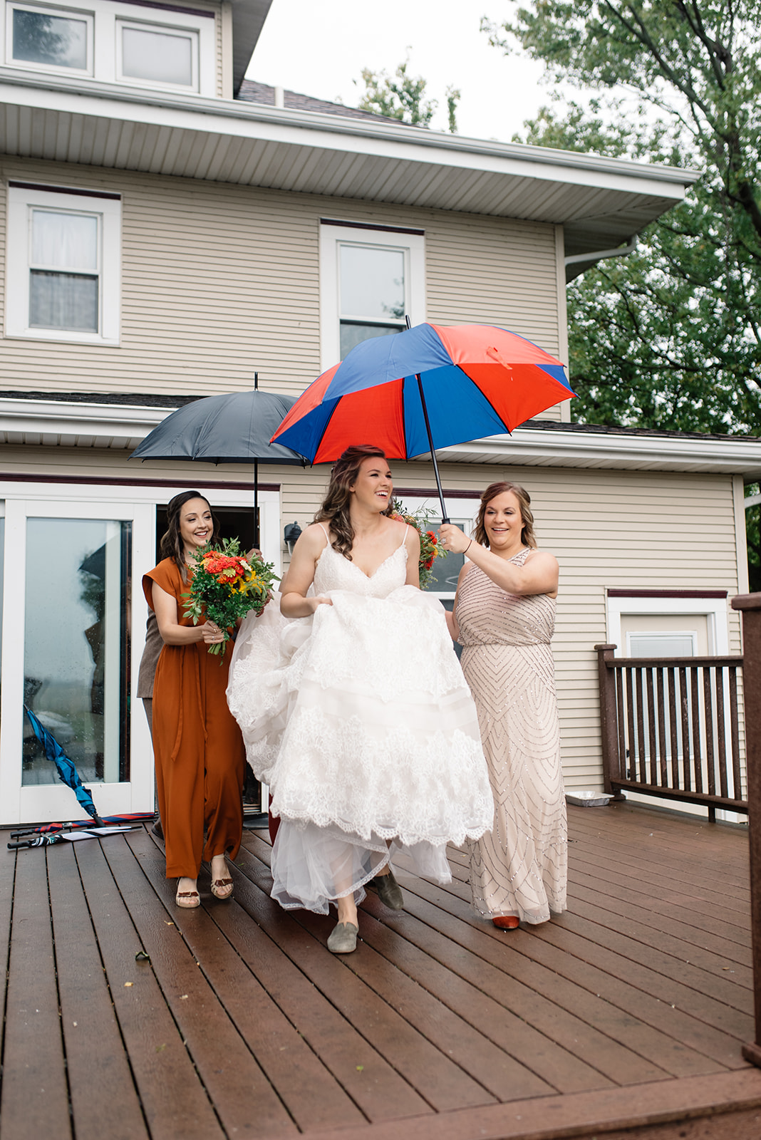 bride and bridesmaids walking outside umbrellas october iowa wedding