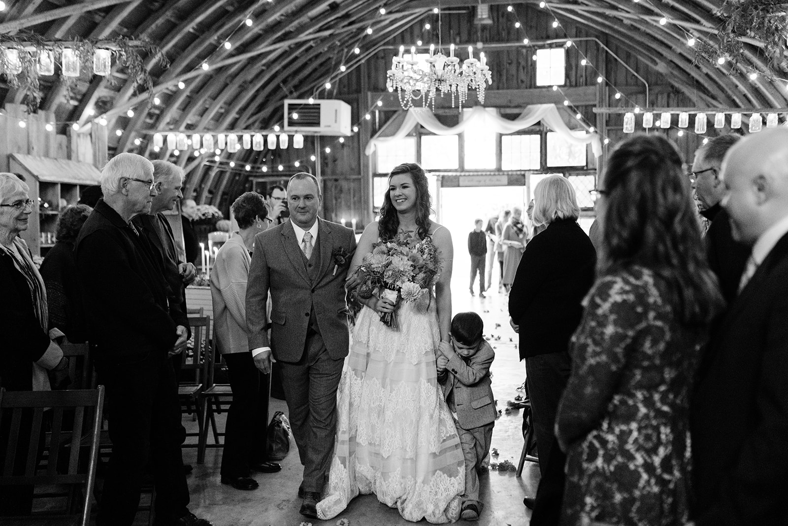 bride walking down aisle under bistro lights iowa city fall wedding