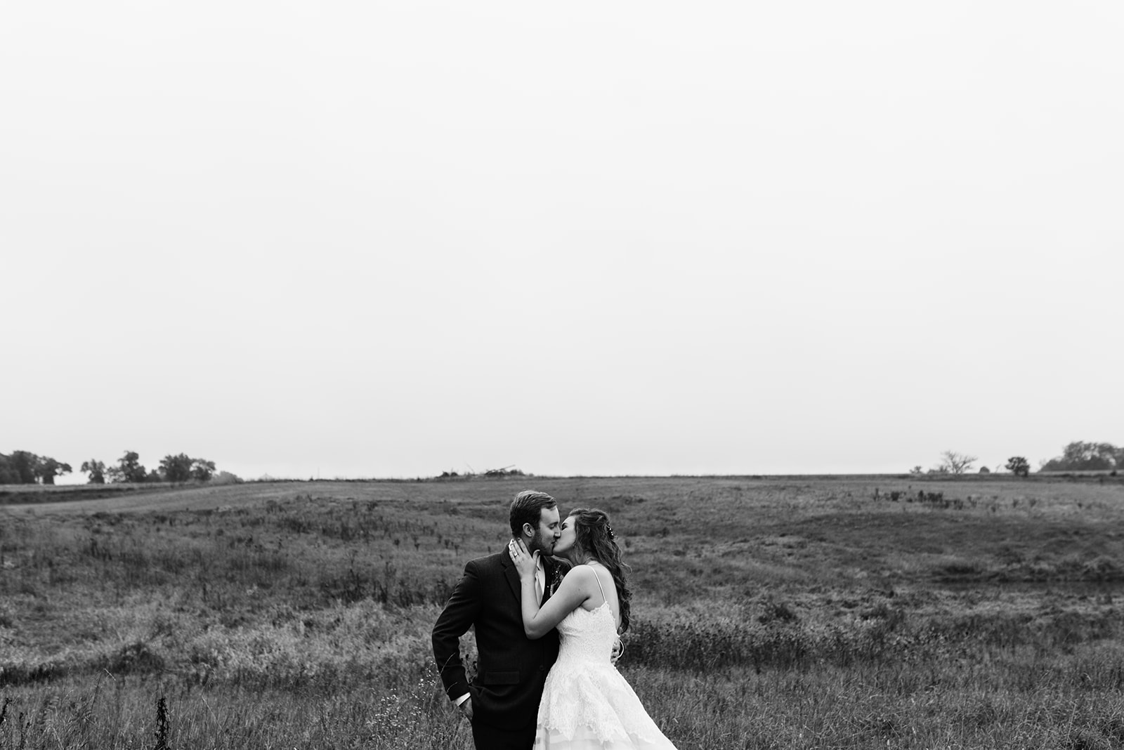 bride and groom kissing in field wellman iowa wedding