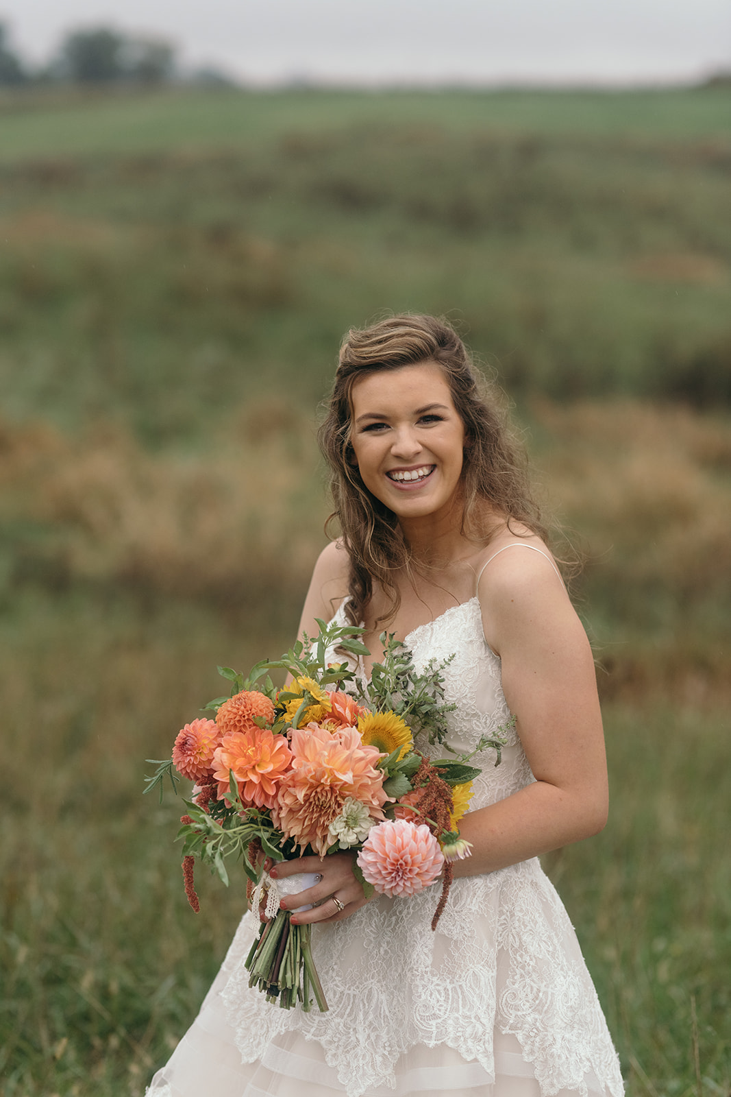 bride holding wild flower bouquet under a tin roof wedding