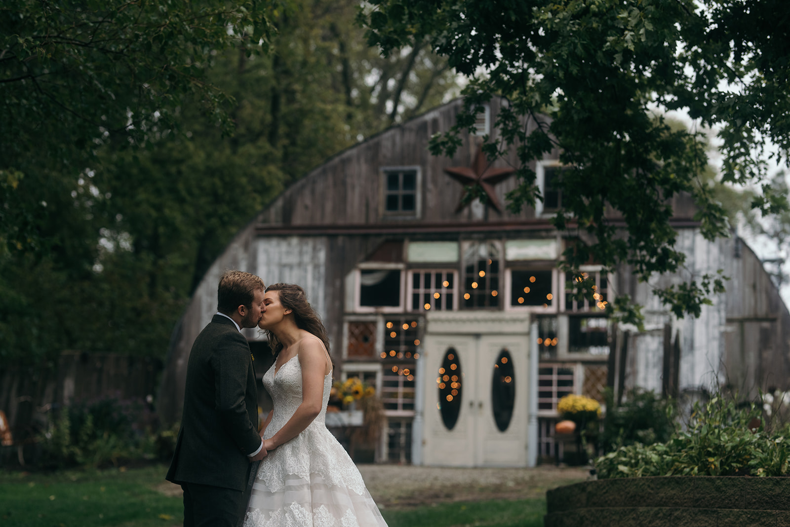 bride and groom kissing outside the barn wedding venue