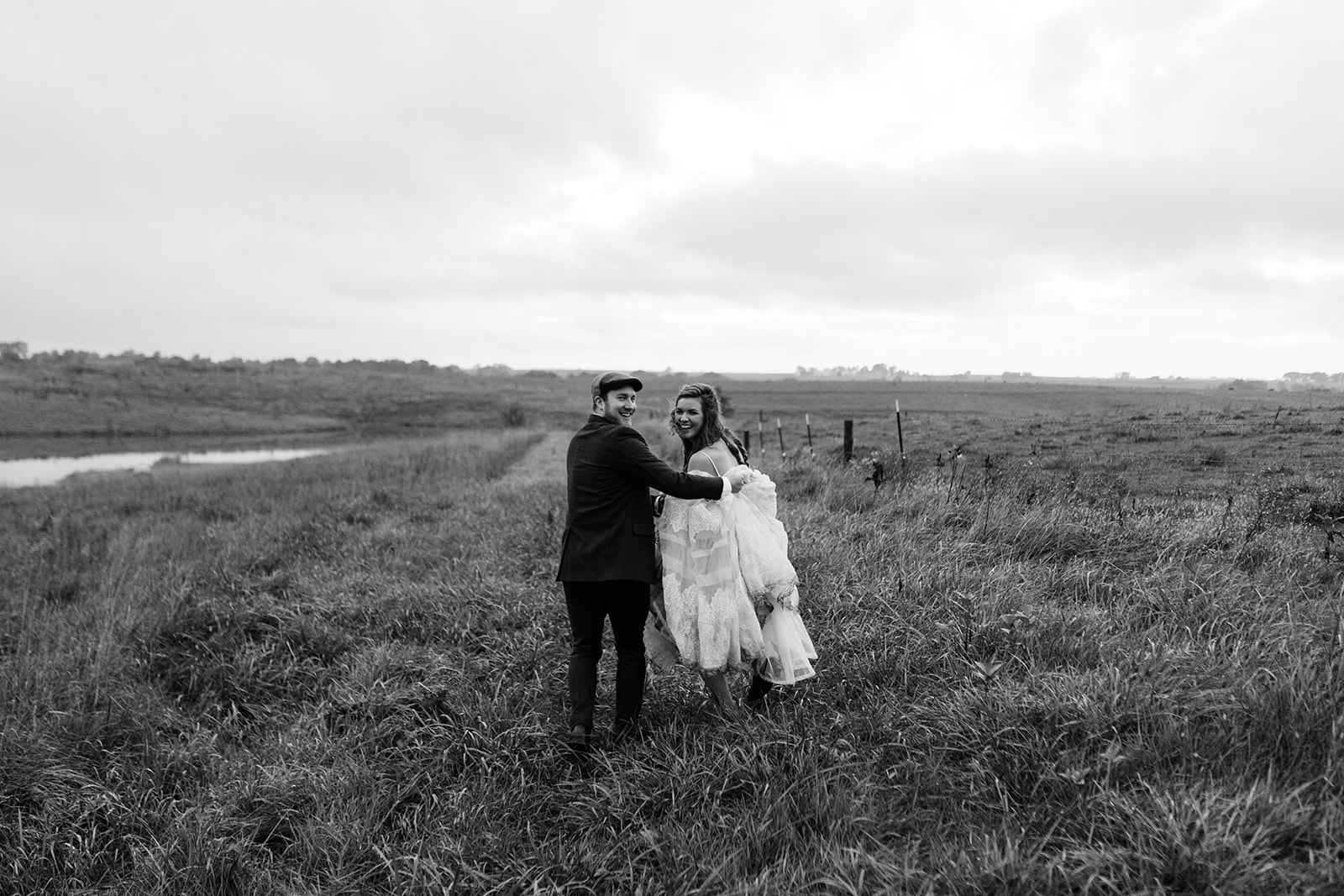 bride and groom running in field iowa fall wedding