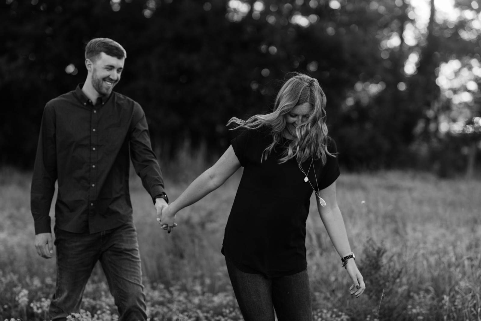 couple walking in field george wyth state park engagement