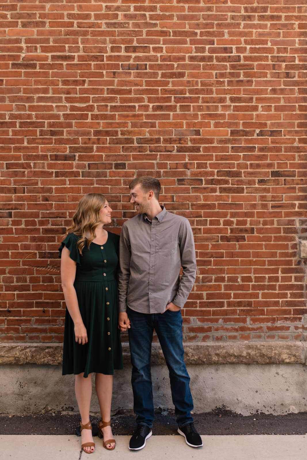 couple standing by brick wall cedar falls engagement