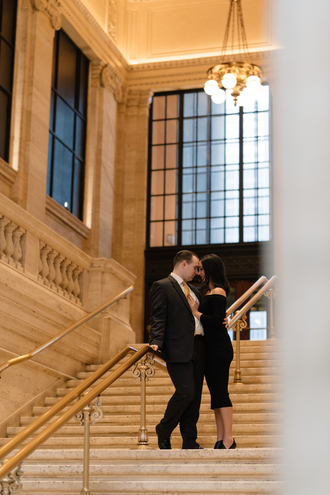 Couple cuddling on stairs at union station engagement