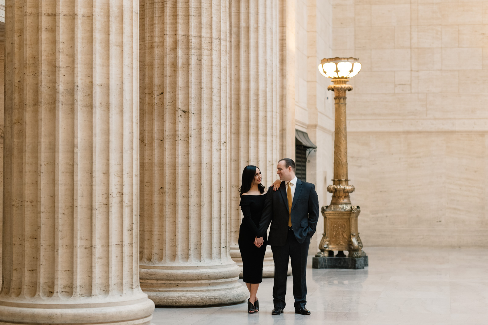 couple standing next to pillars at chicago union station engagement