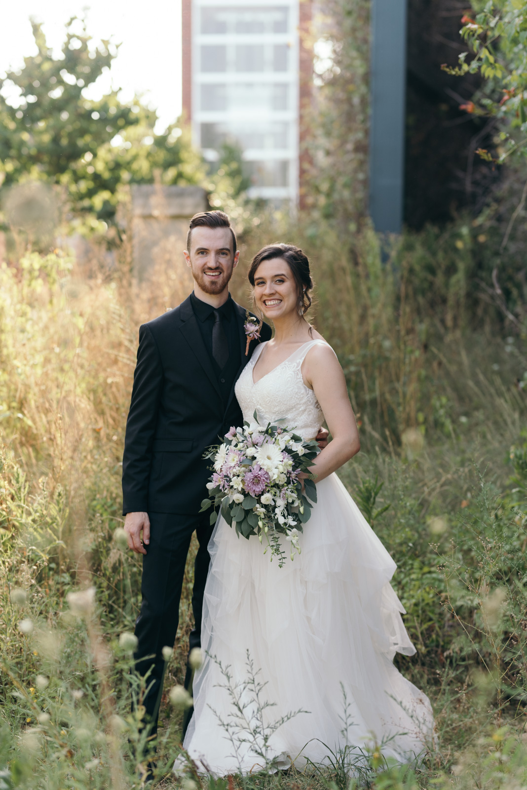 bride and groom smiling outside iowa city wedding