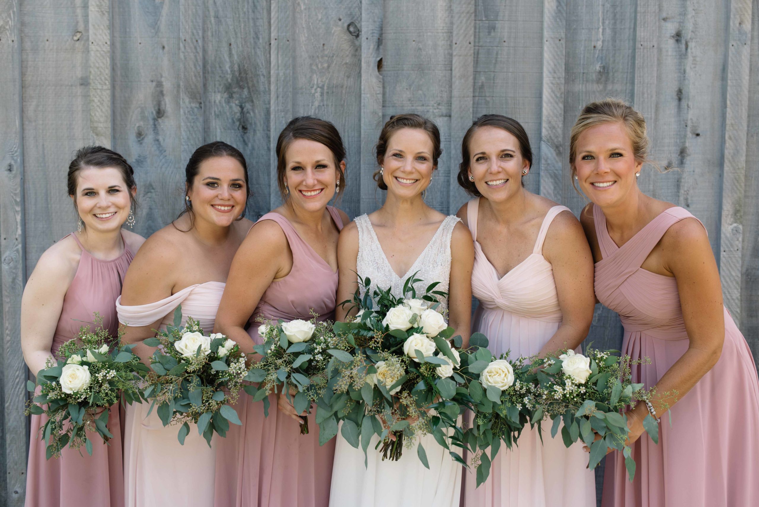 bridesmaid in blush pink dresses and gray wood barn schafer century barn wedding venue