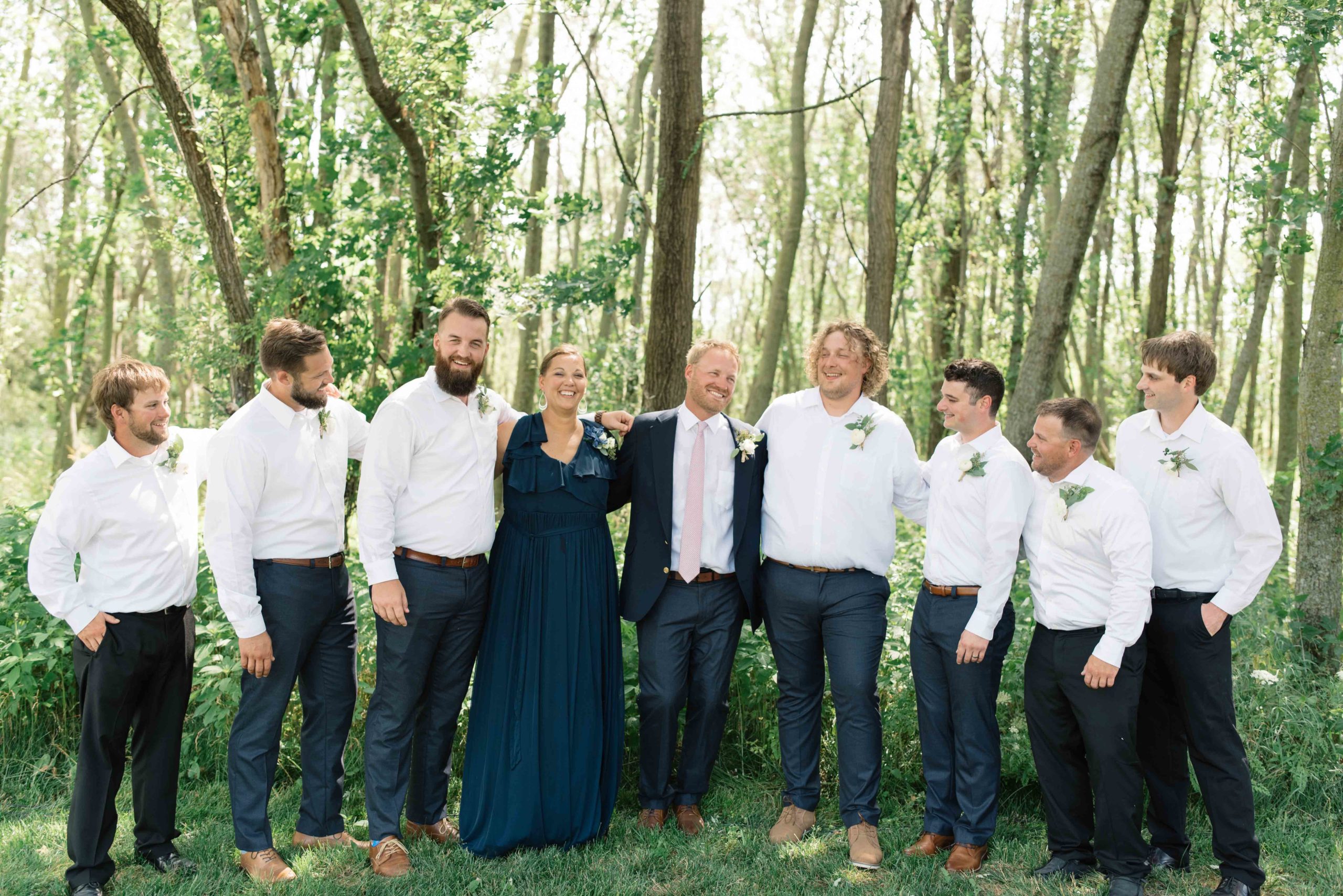 groomsmen laughing with groom schafer century barn Iowa wedding venue