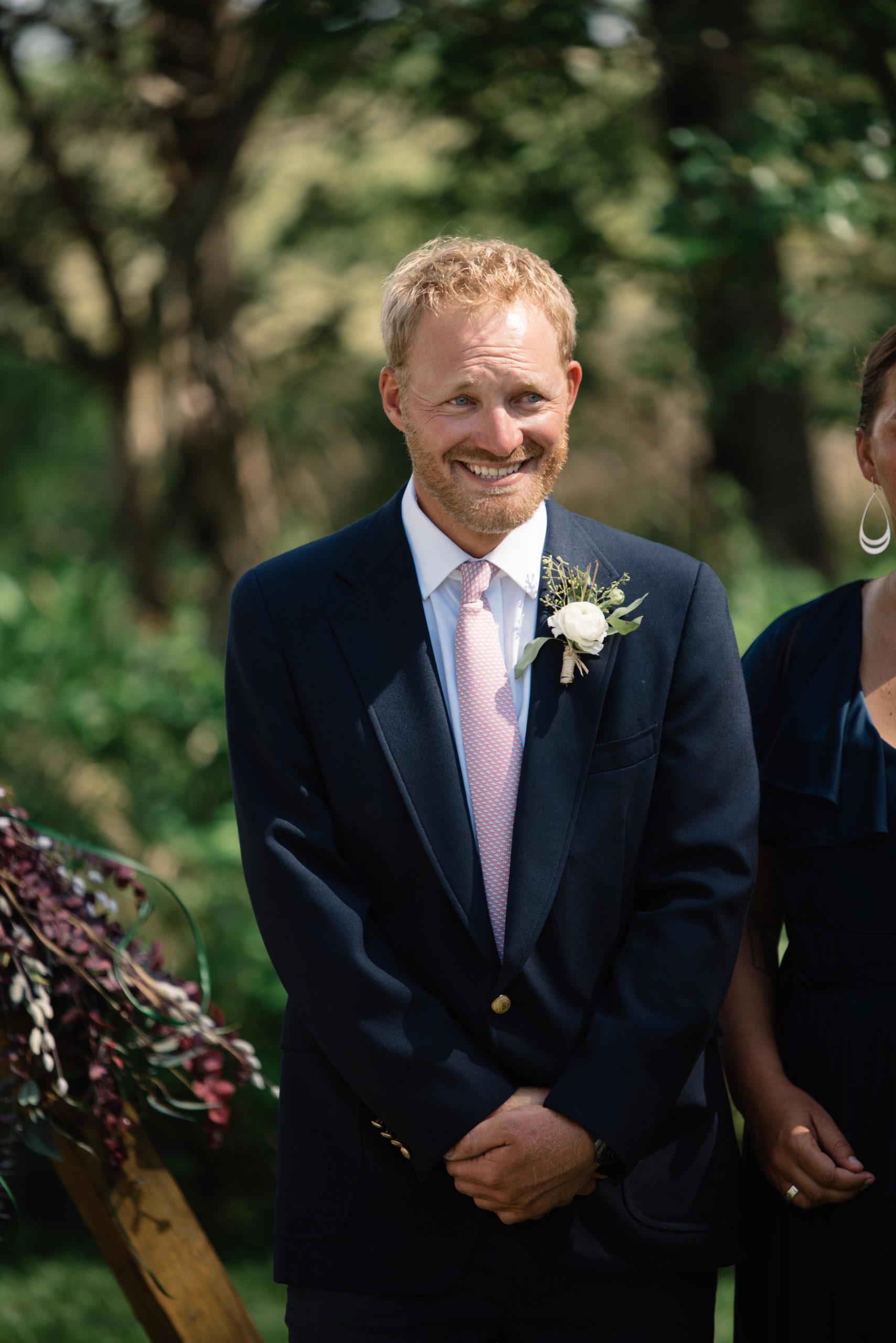 groom smiling as he sees his bride for the first time outdoor Iowa wedding ceremony schafer century barn wedding venue