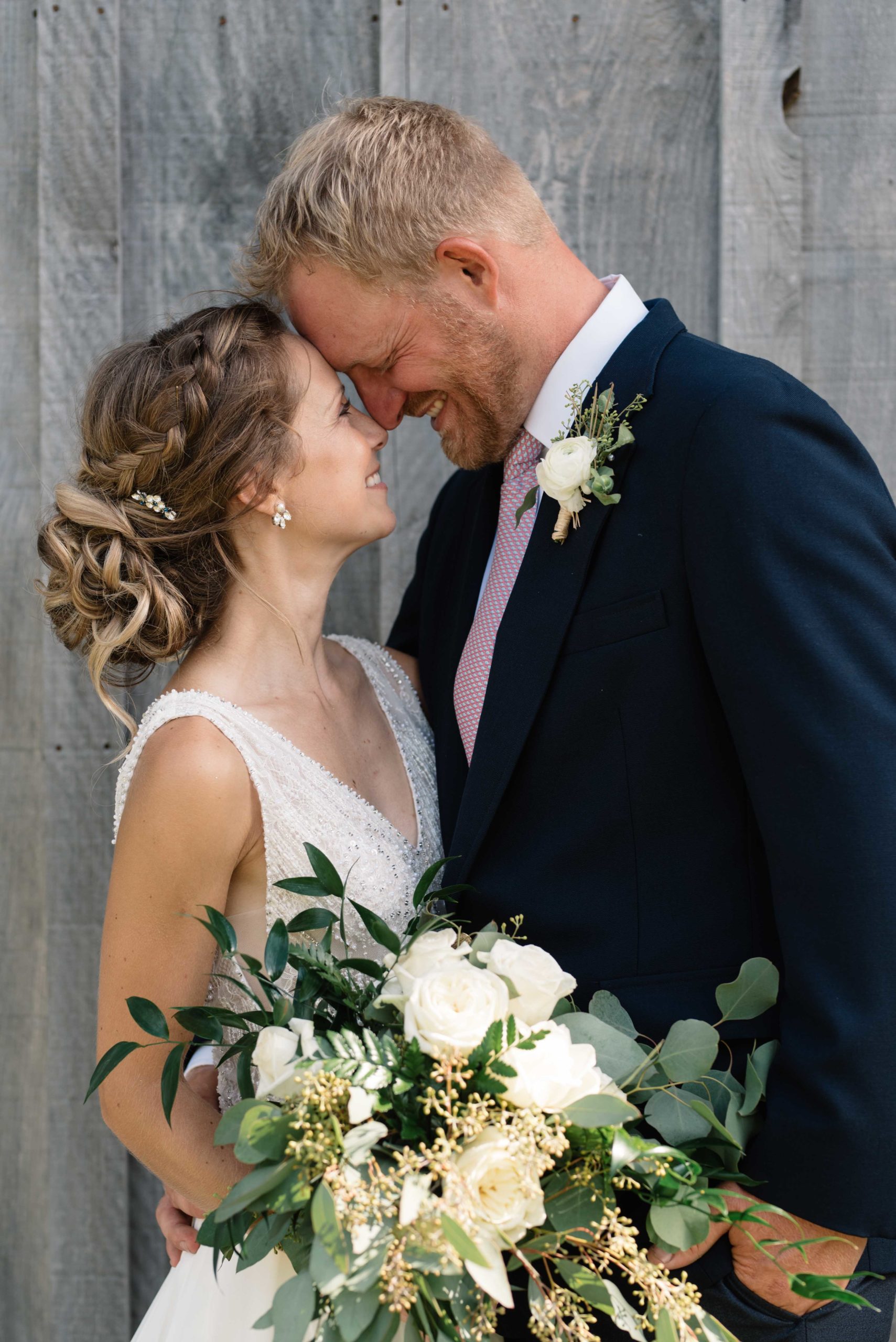 bride and groom in front of gray barn schafer century barn wedding venue