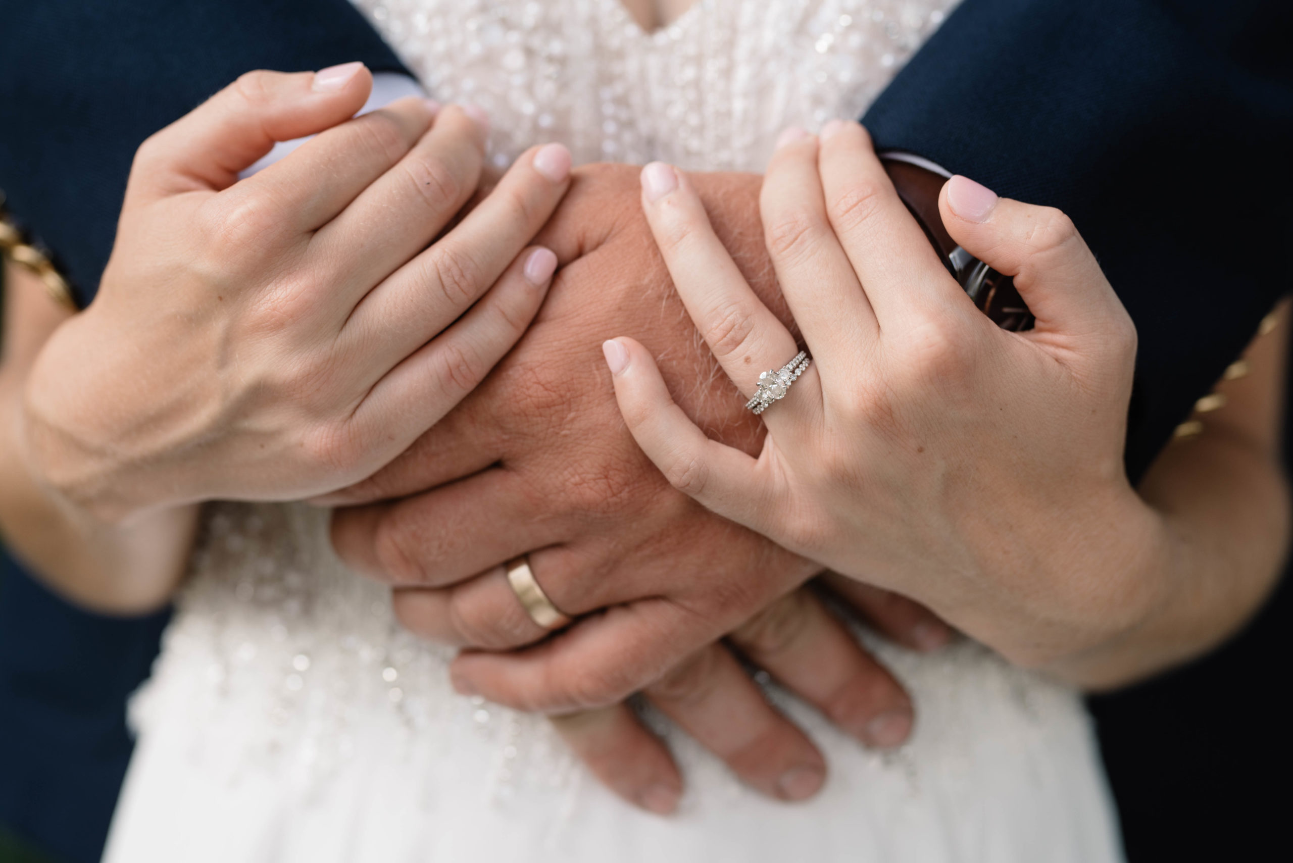 close up of bride and groom hands with wedding rings schafer century barn wedding venue