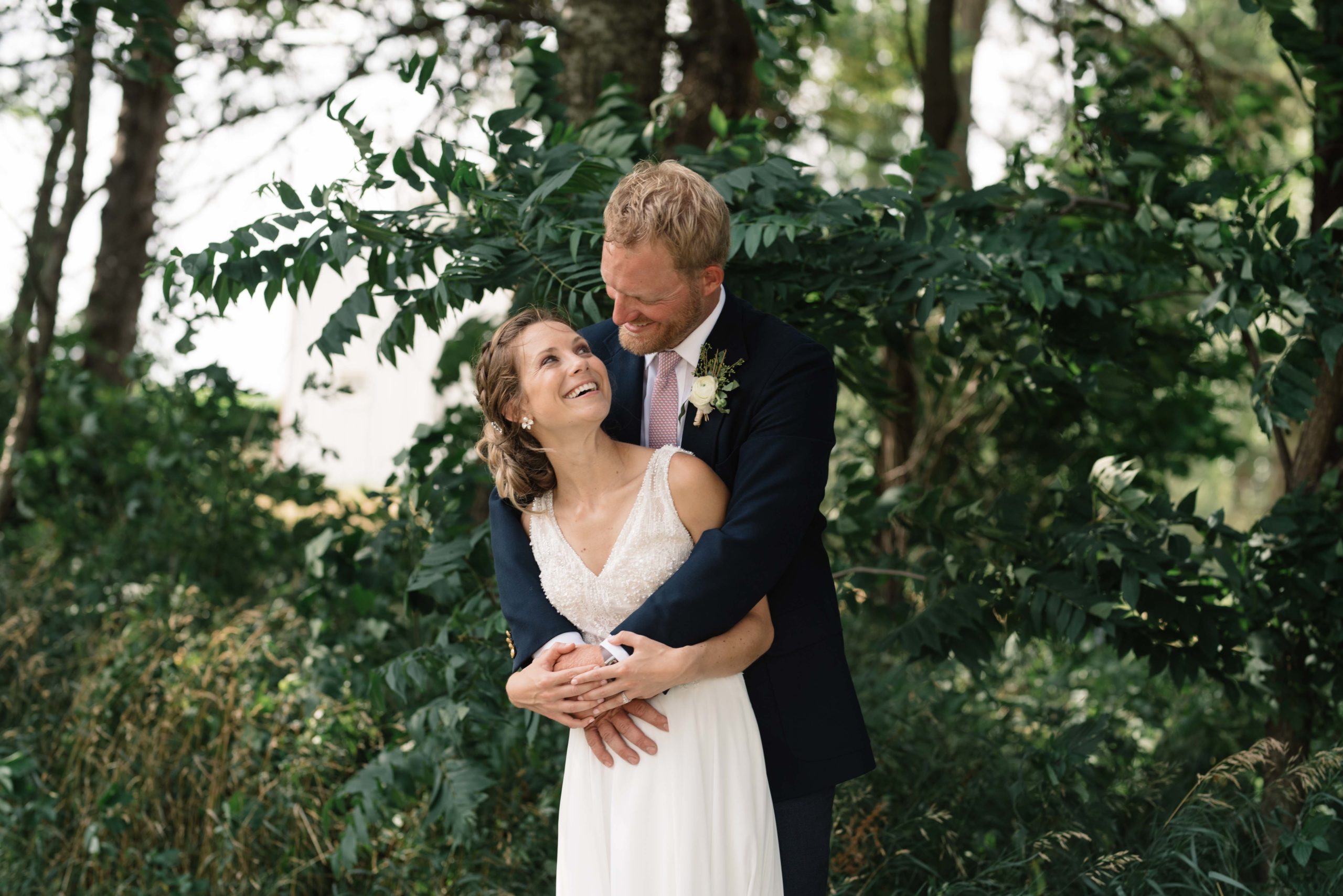 bride and groom hug by green tree schafer century barn wedding venue