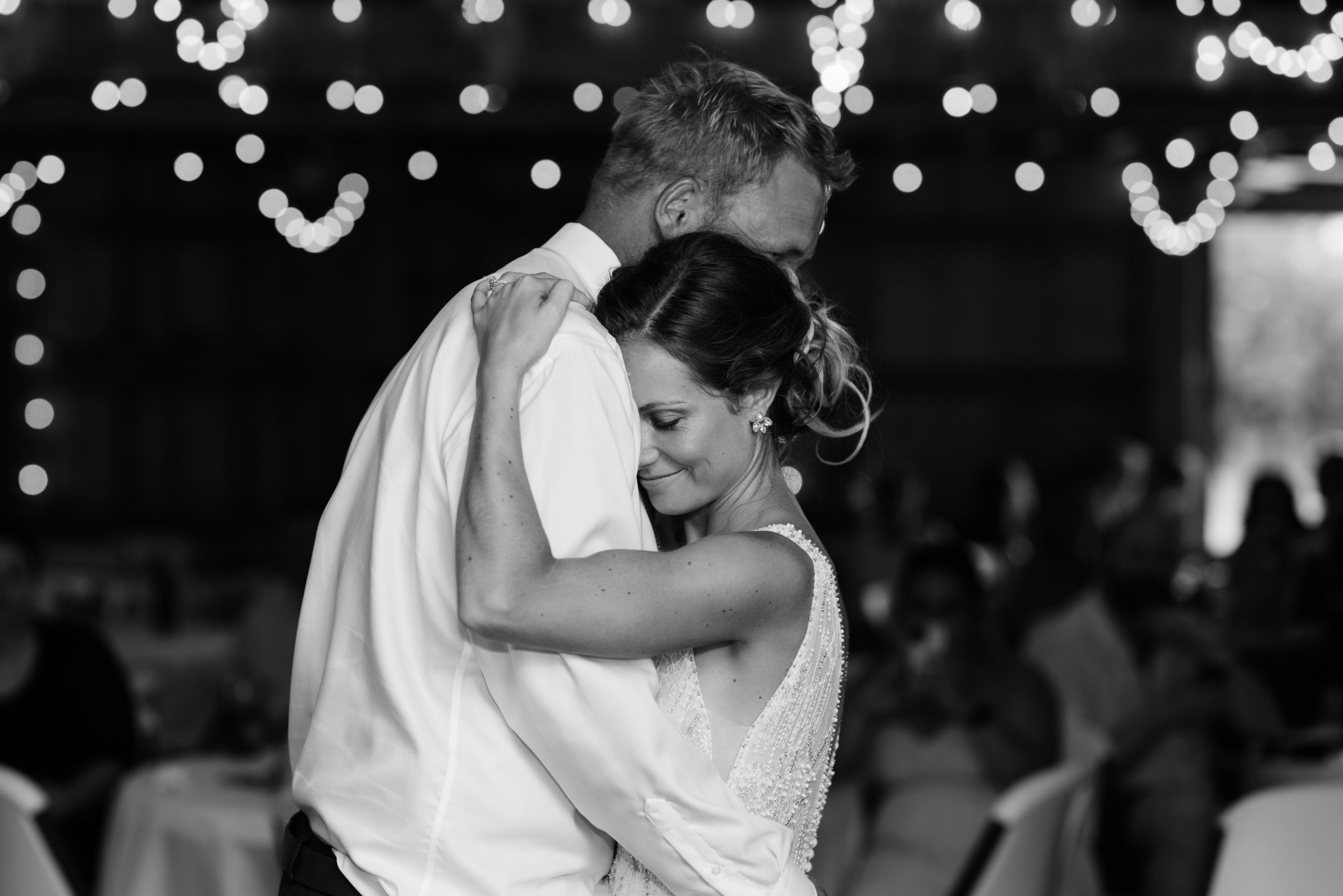 bride and groom first dance under twinkly edison bulb lights schafer century barn wedding venue