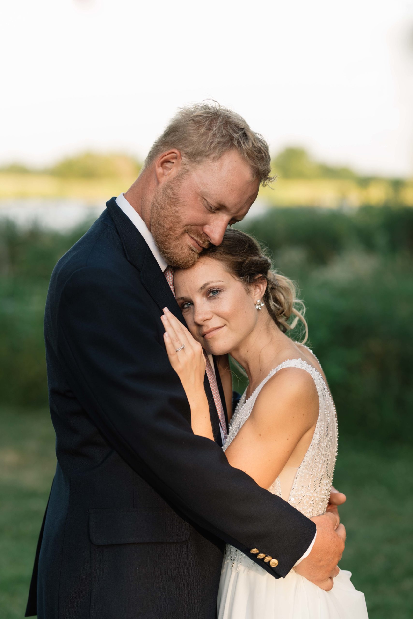 bride and groom snuggle under wooden triangle wedding ceremony arch schafer century barn wedding venue