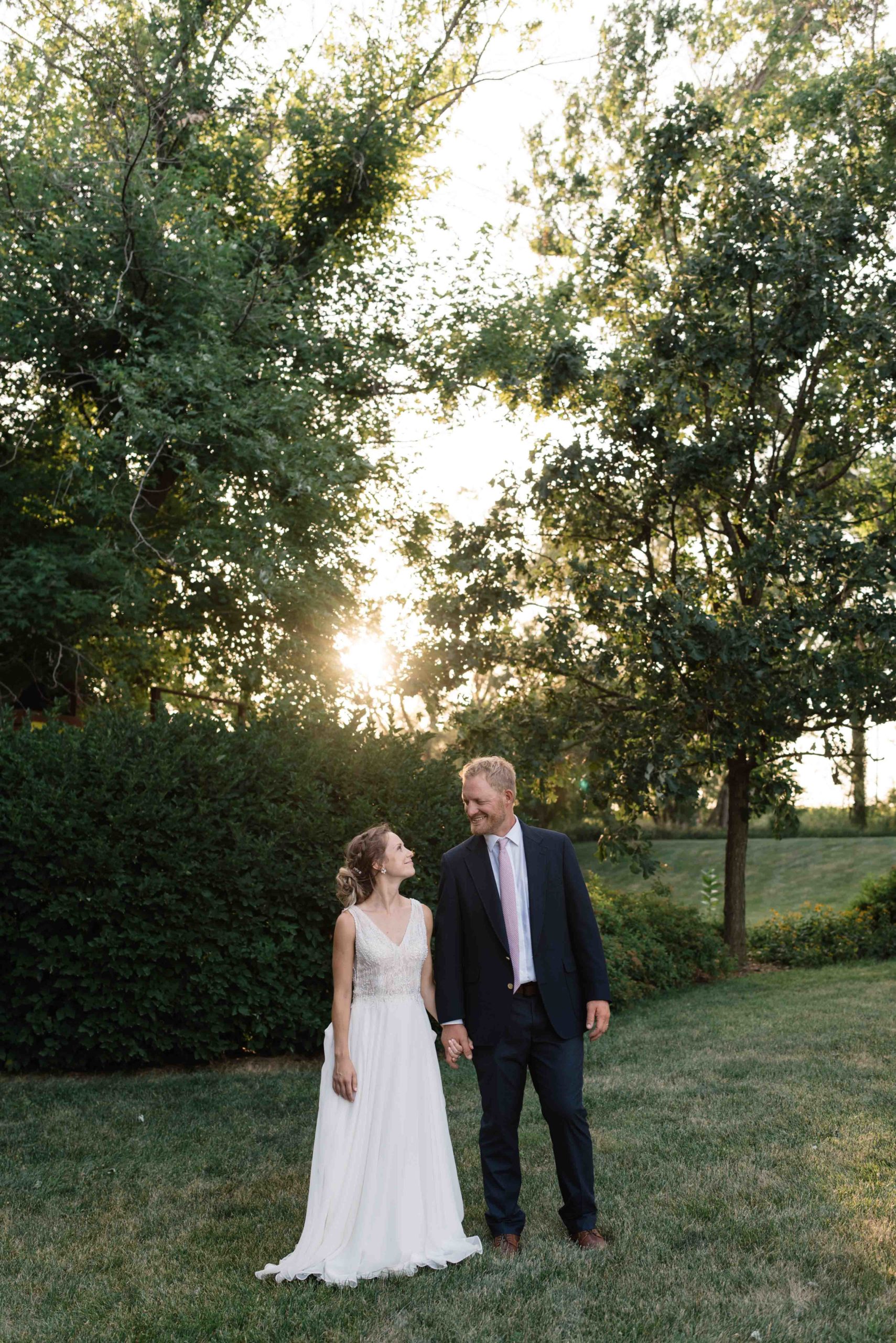 bride and groom holding hands at sunset outside schafer century barn wedding venue