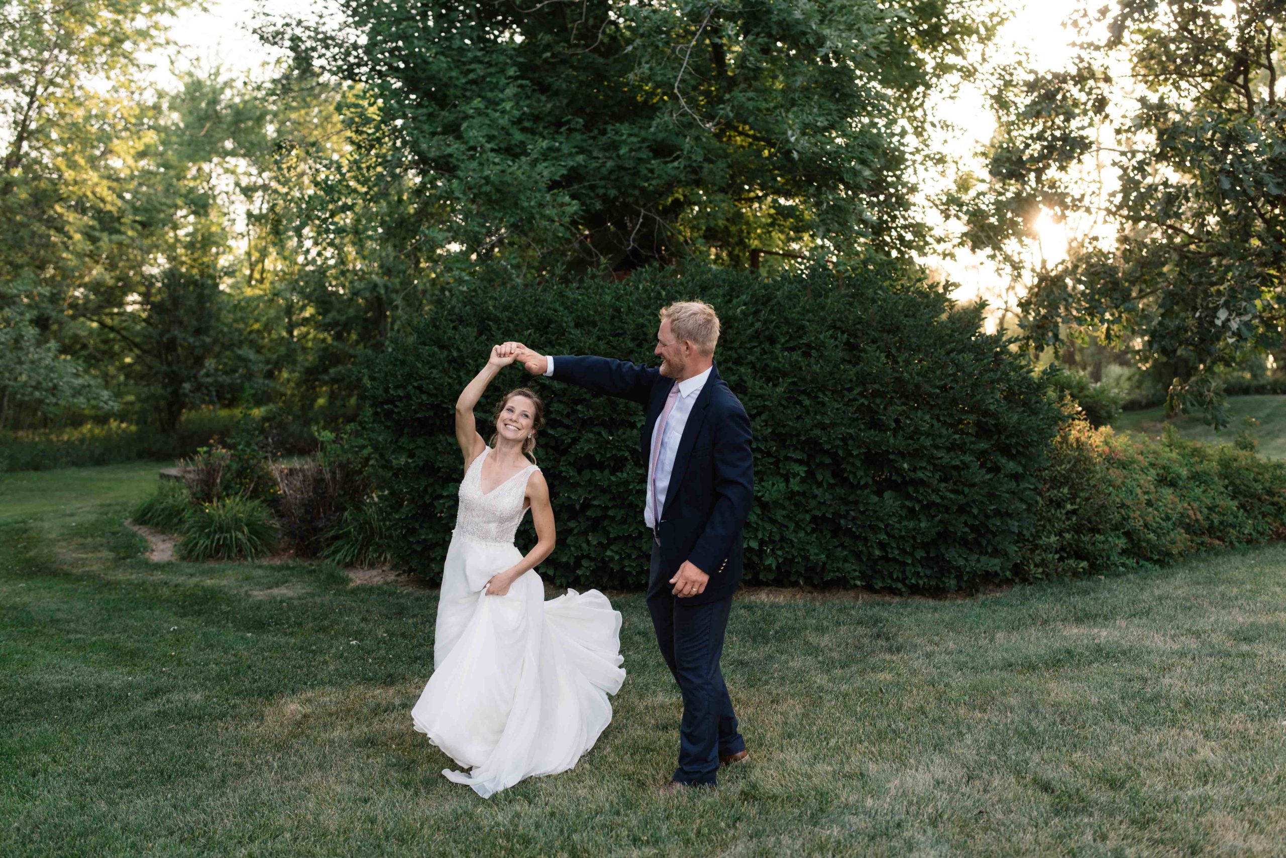 bride and groom twirling at sunset outside of schafer century barn wedding venue