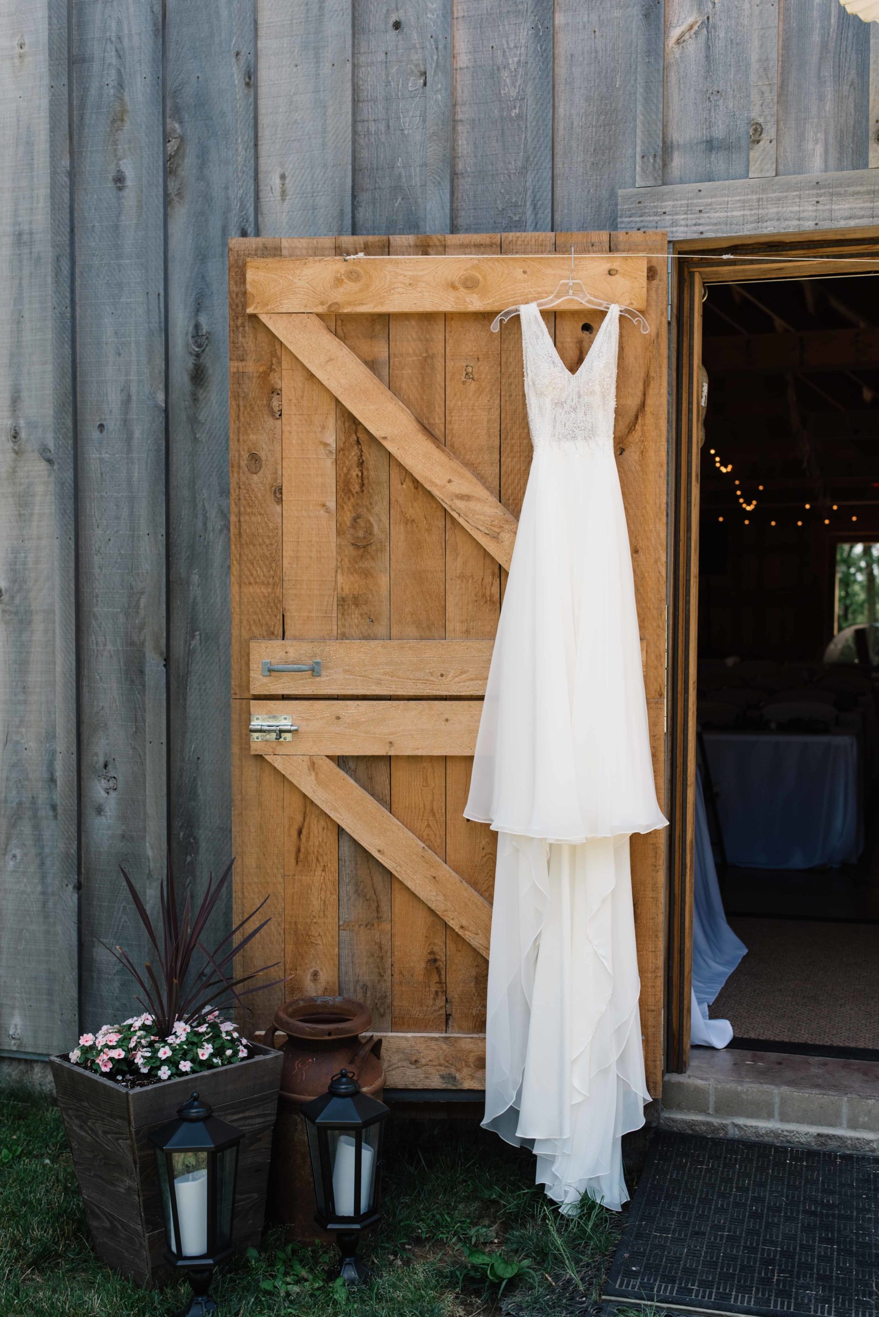 wedding dress hanging on barn door schafer century barn wedding venue