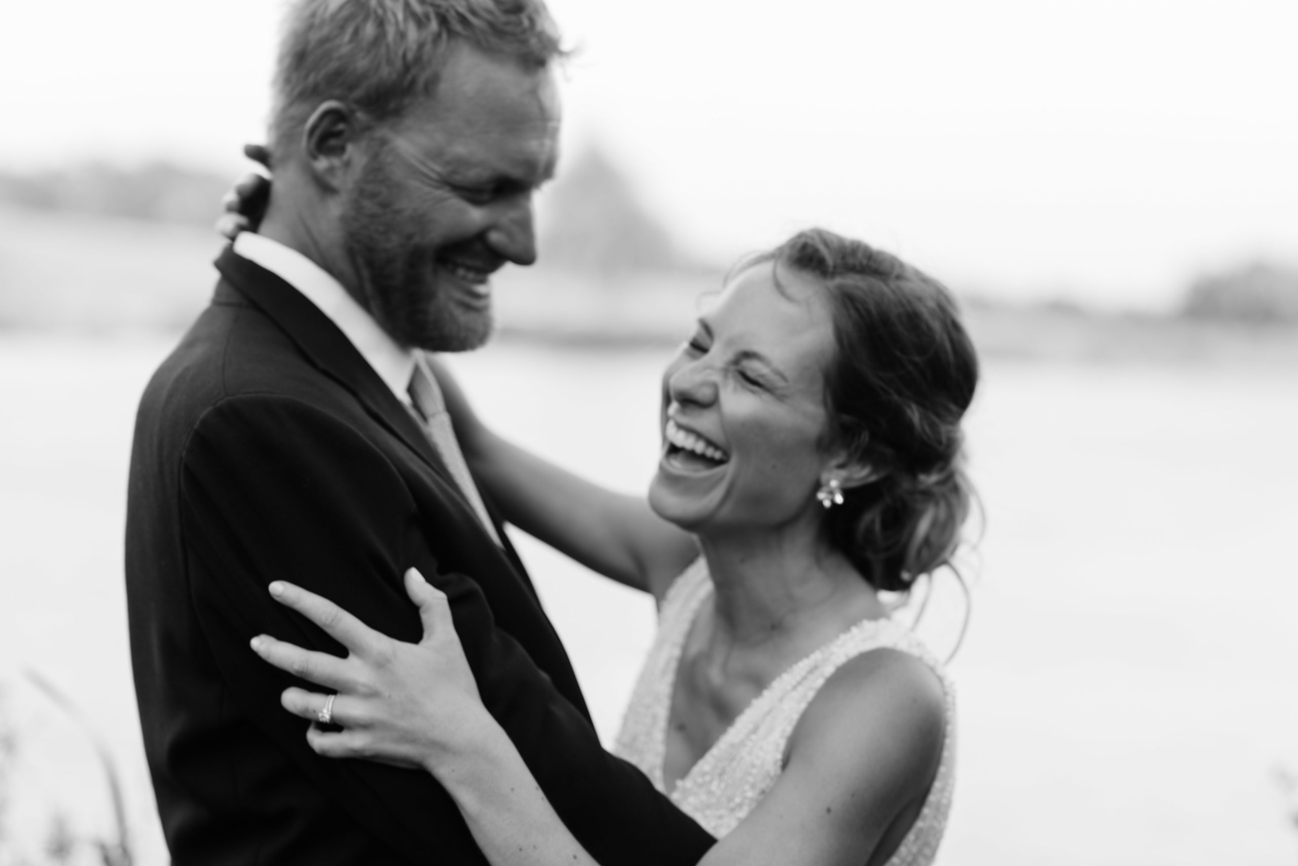 bride and groom laughing at sunset outside of schafer century barn wedding venue near des moines iowa