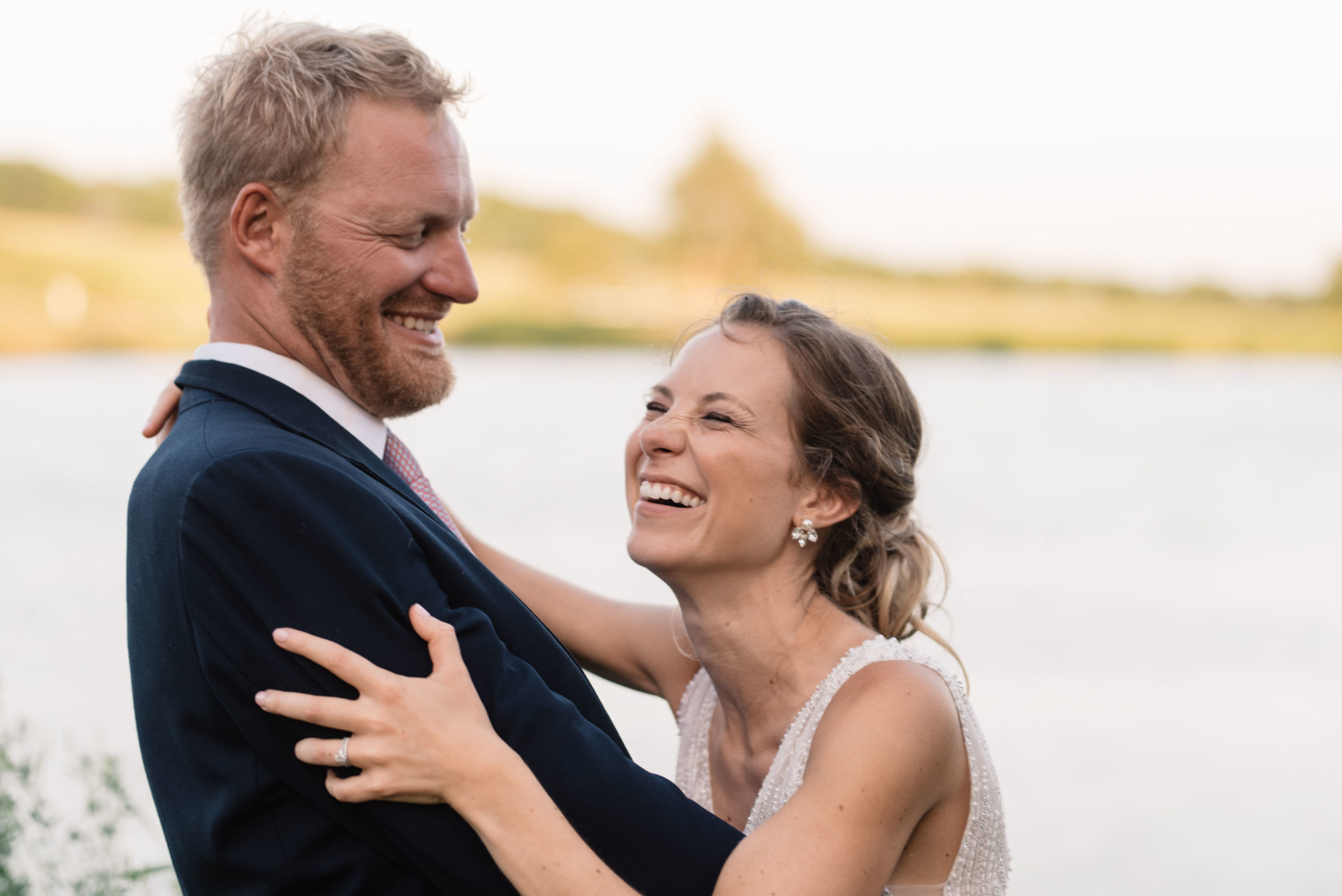 bride and groom laughing at sunset outside of schafer century barn wedding venue near des moines iowa