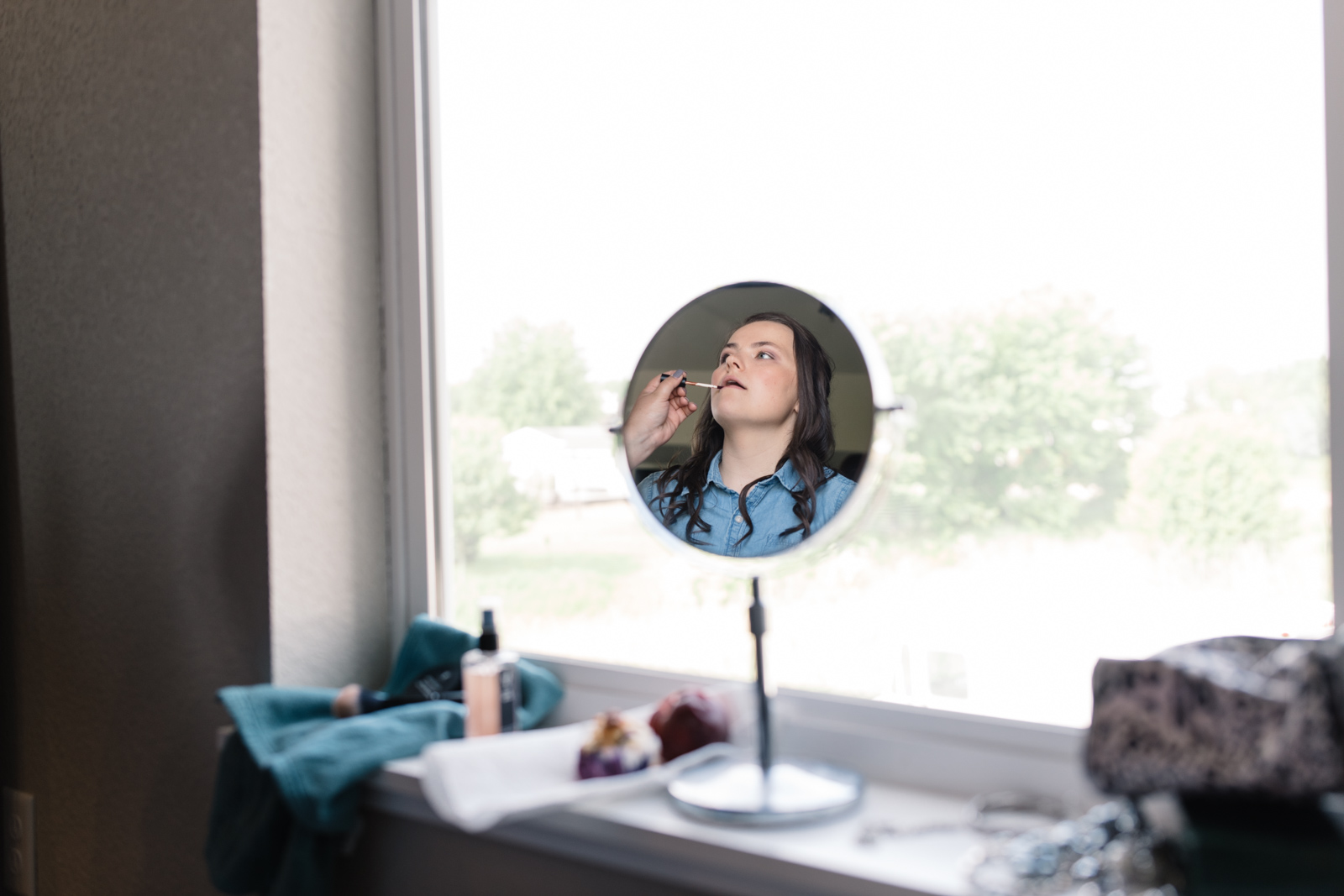 bride's reflection in mirror getting make up done iowa wedding