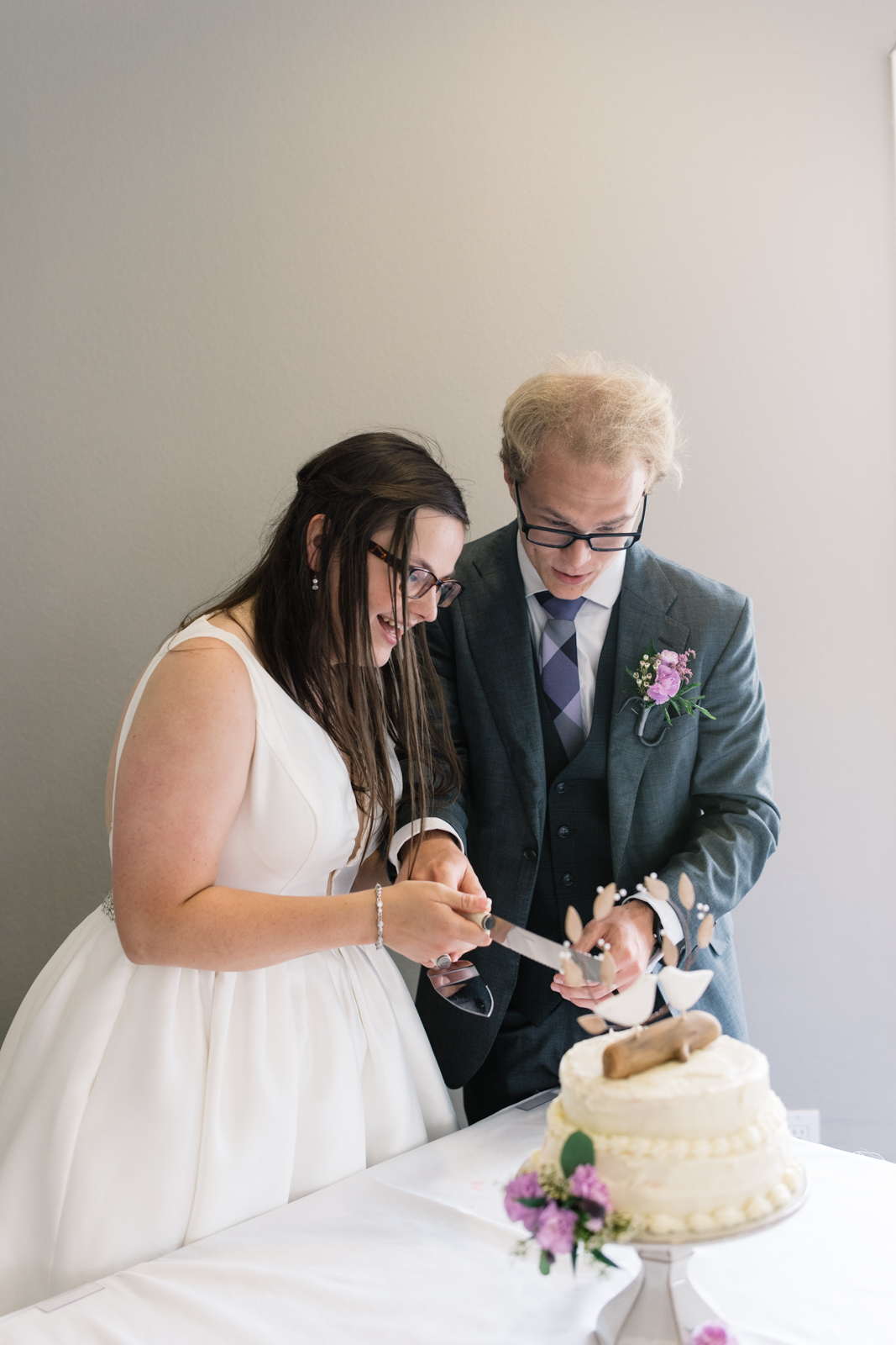 bride and groom cut wedding cake