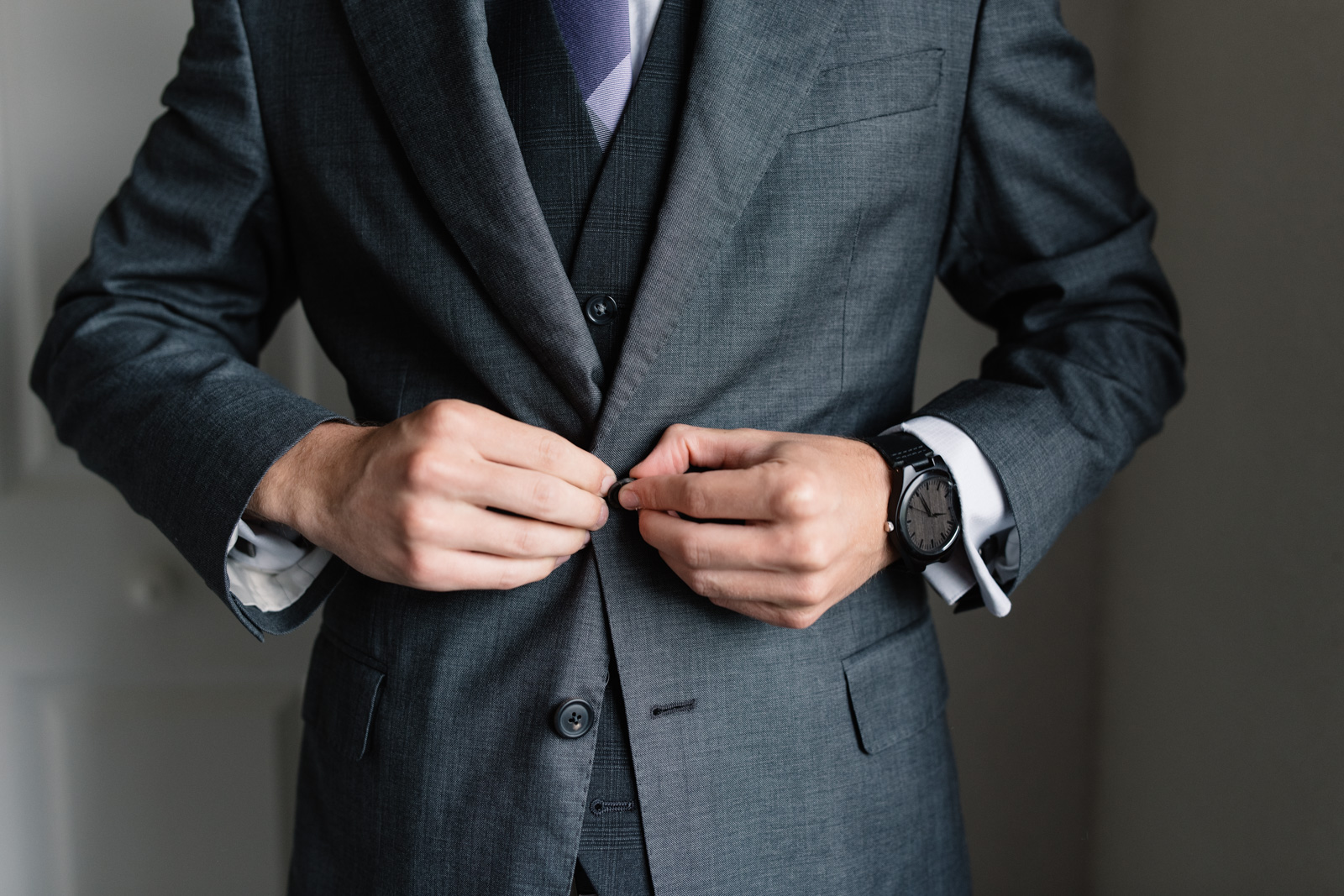 groom buttoning suit jacket iowa wedding