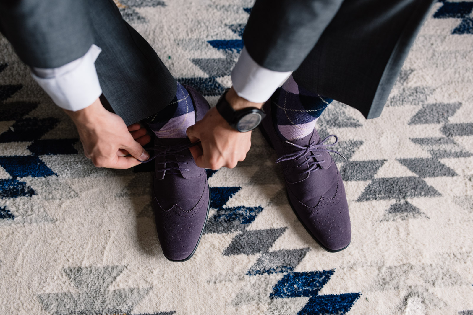 groom tying purple suede dress shoes iowa wedding 