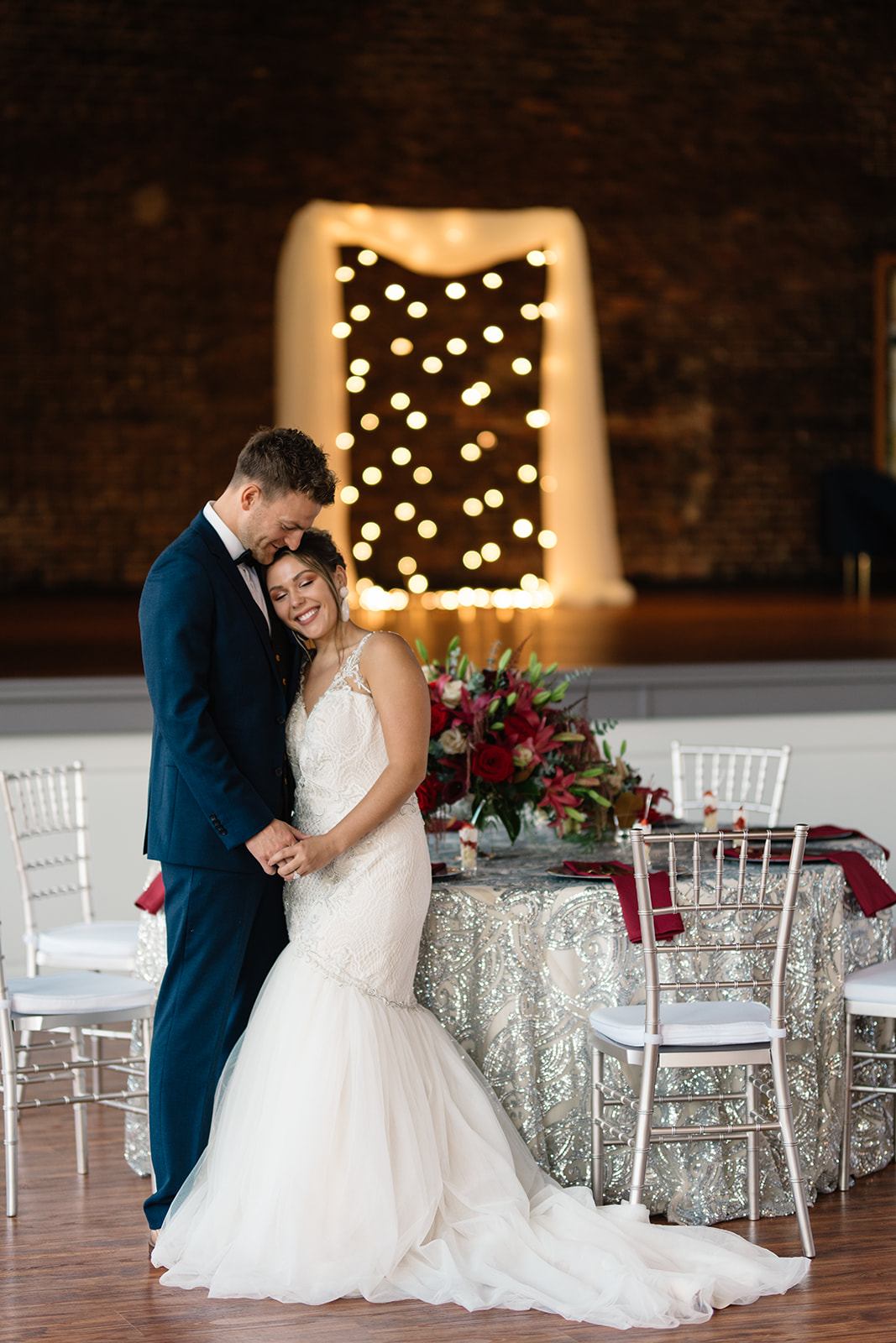 couple under twinkly light wedding arch brick wall olympic south side theater wedding venue cedar rapids