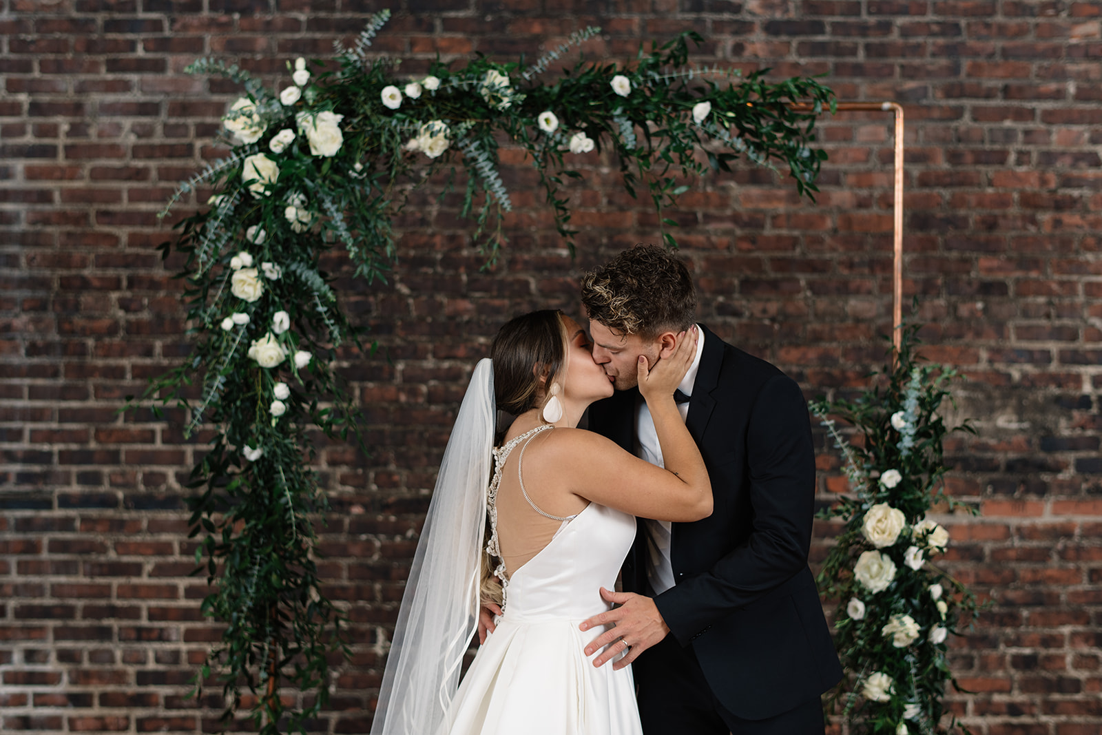 white rose floral copper arbor on brick wall olympic south side wedding venue