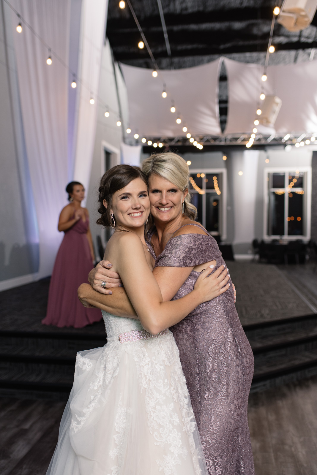 bride and groom first dance under edison bulb lights epic event center cedar rapids wedding venue