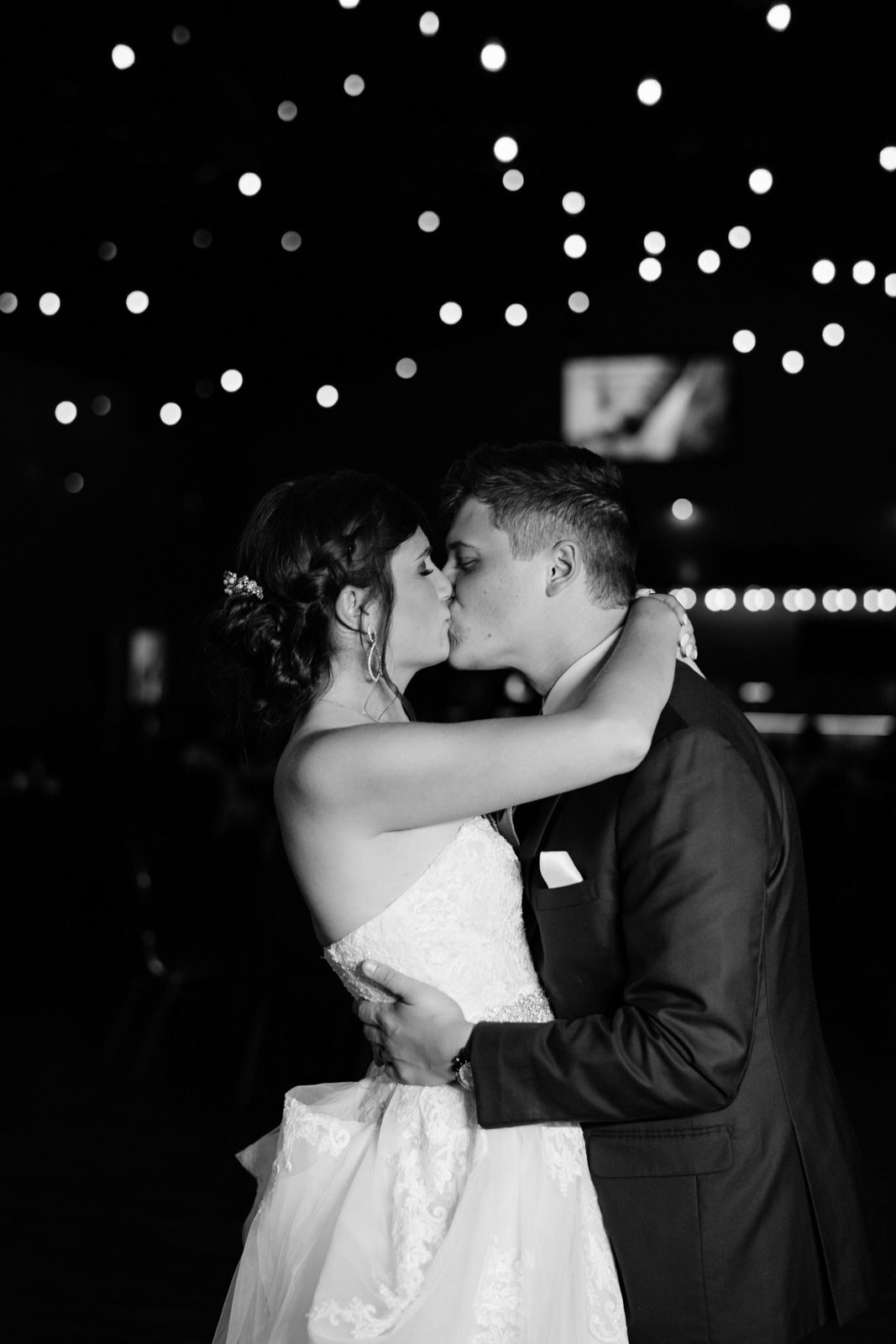 bride and groom first dance under edison bulb lights epic event center cedar rapids wedding venue