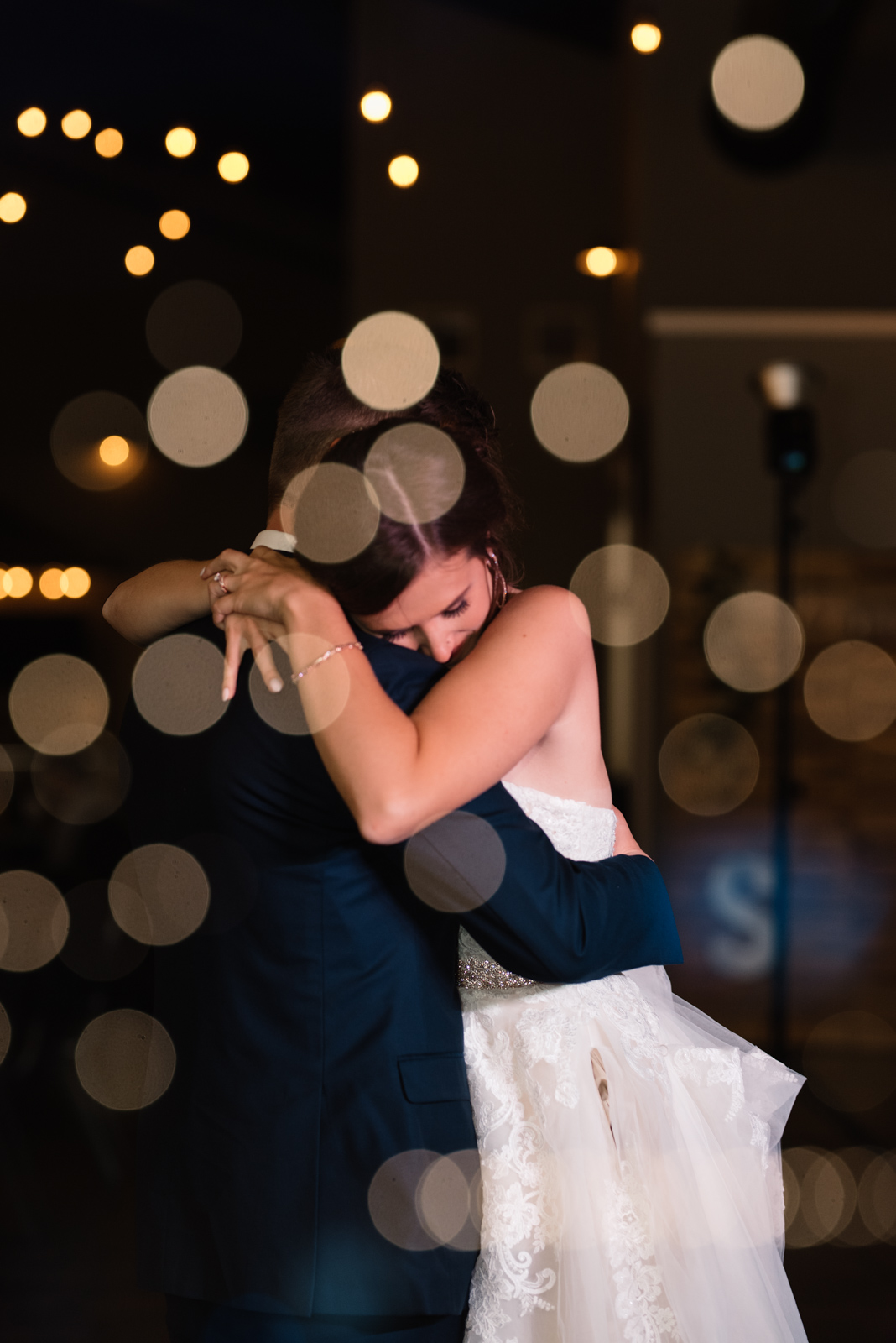 bride and groom first dance under edison bulb lights epic event center cedar rapids wedding venue