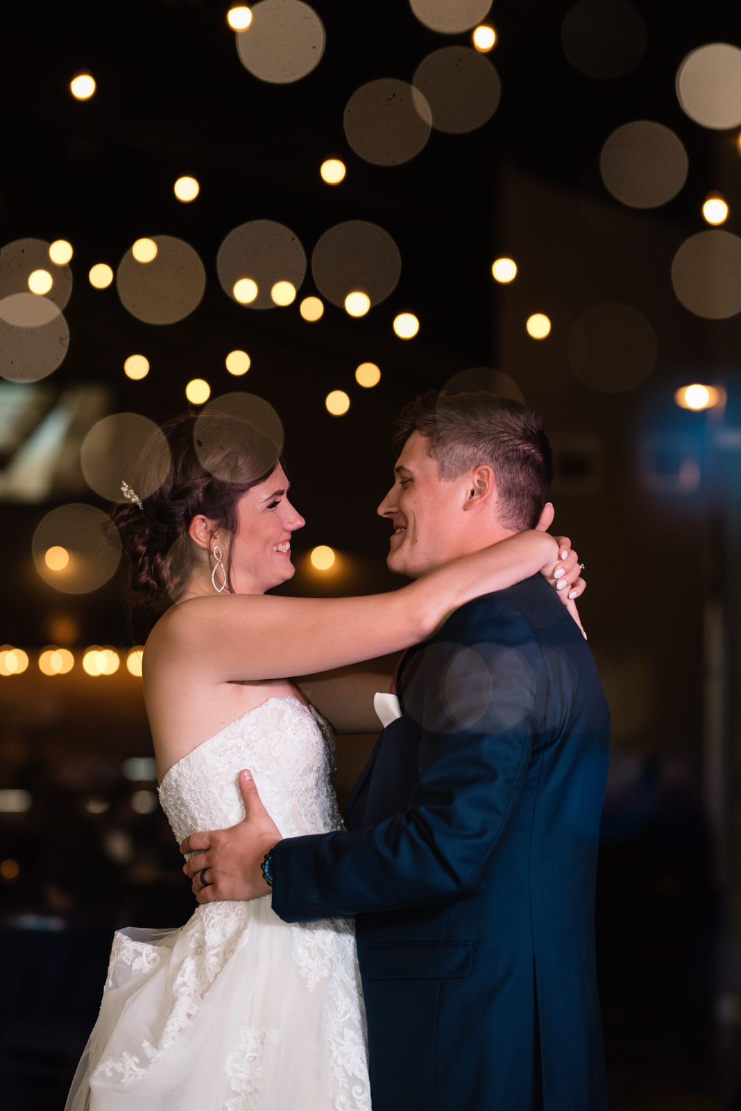 bride and groom first dance under edison bulb lights epic event center cedar rapids wedding venue