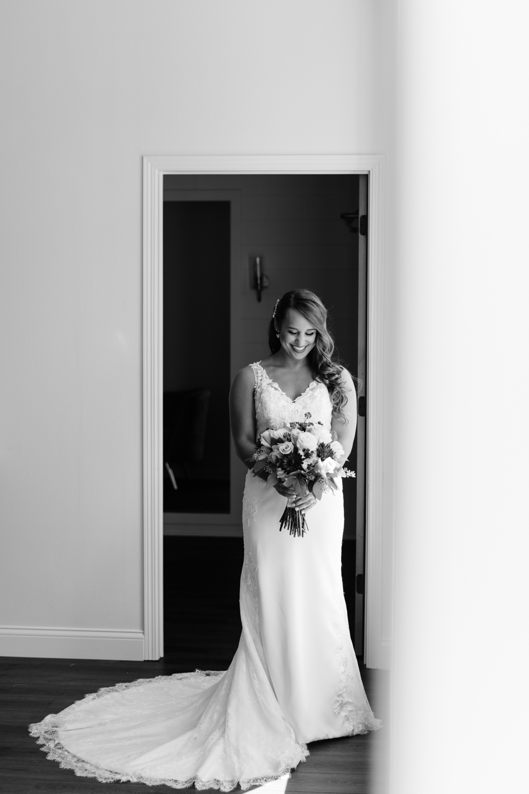 bride holding bouquet in window light bella sala bridal suite