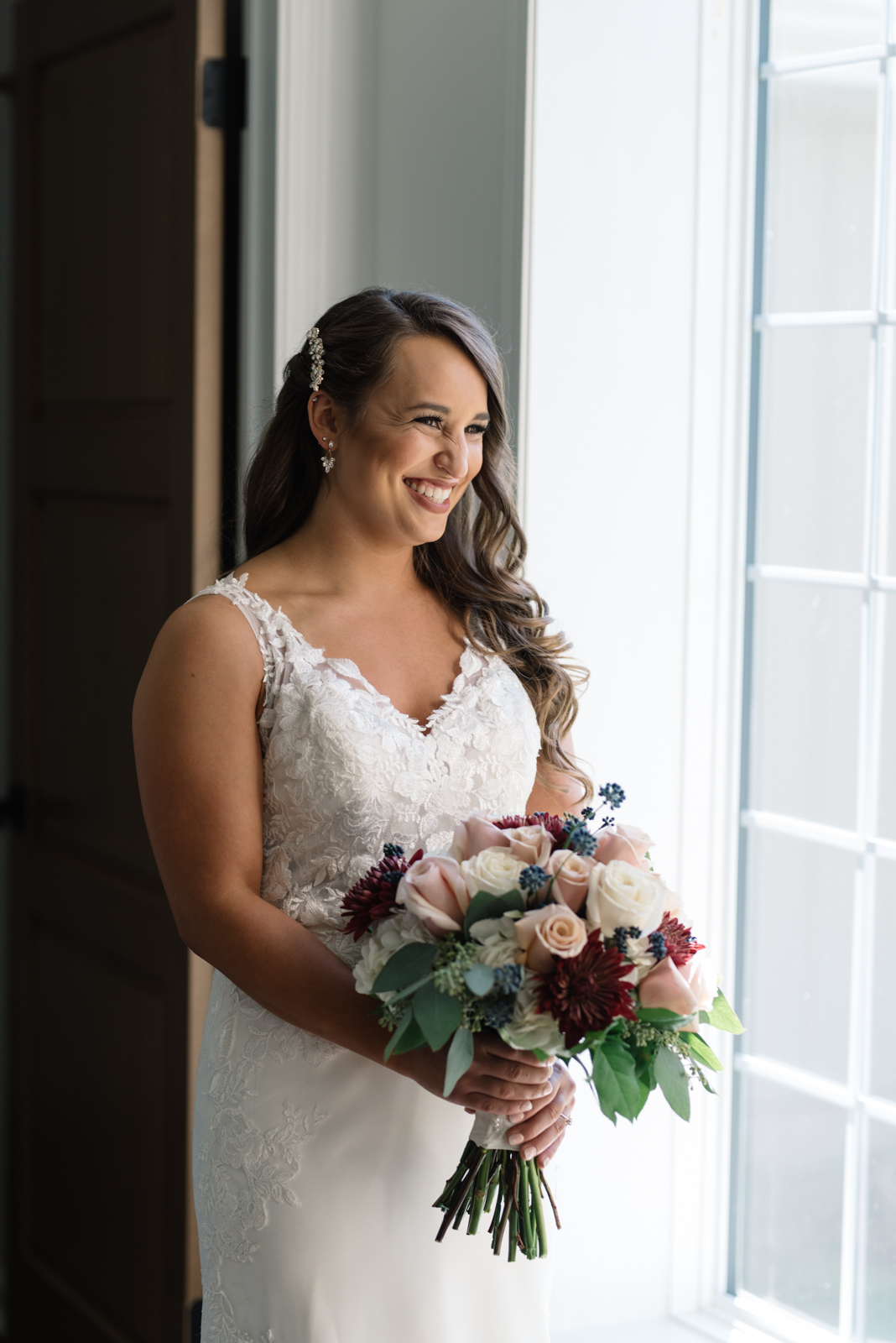 bride holding bouquet in window light bella sala bridal suite