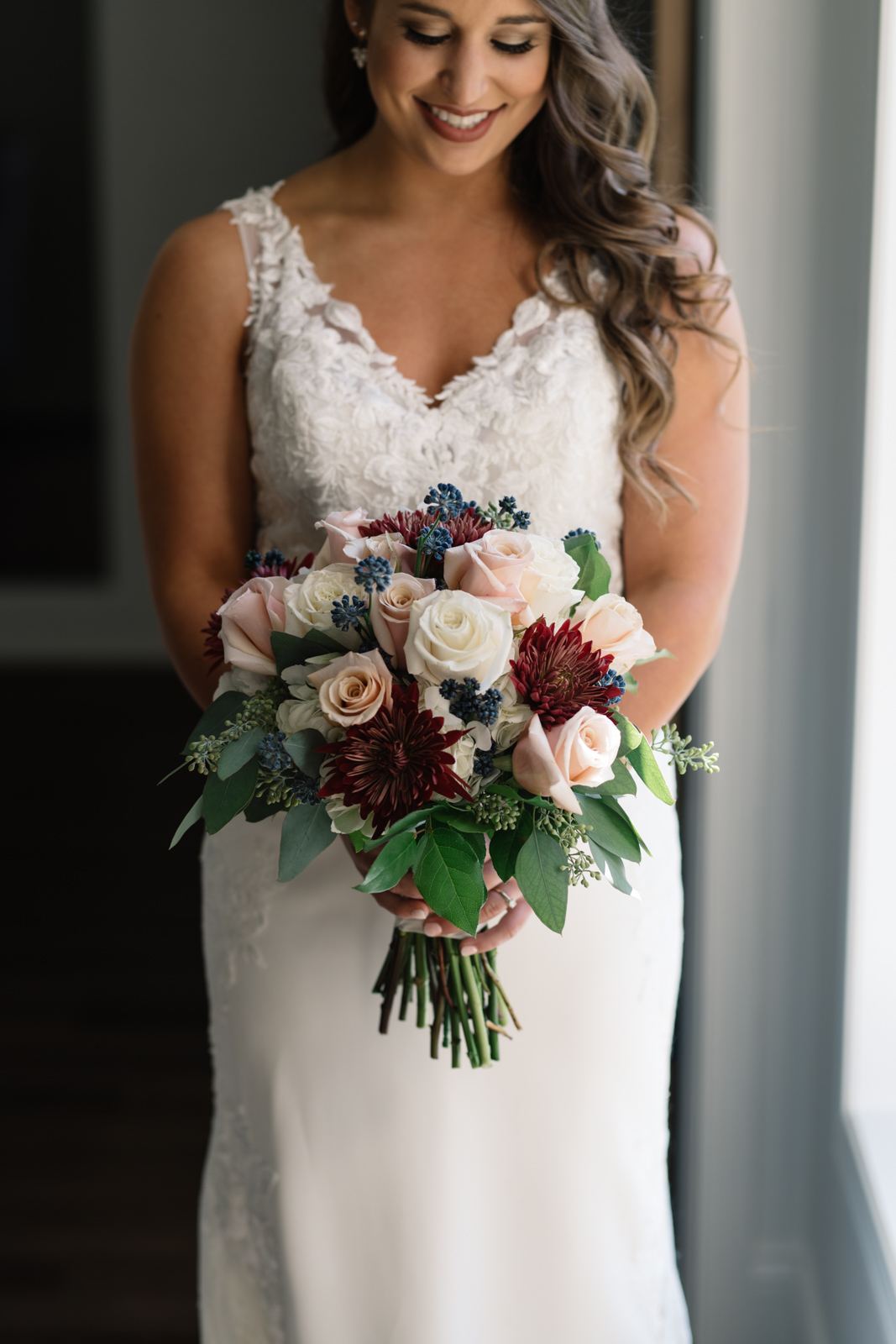 bride holding bouquet in window light bella sala bridal suite