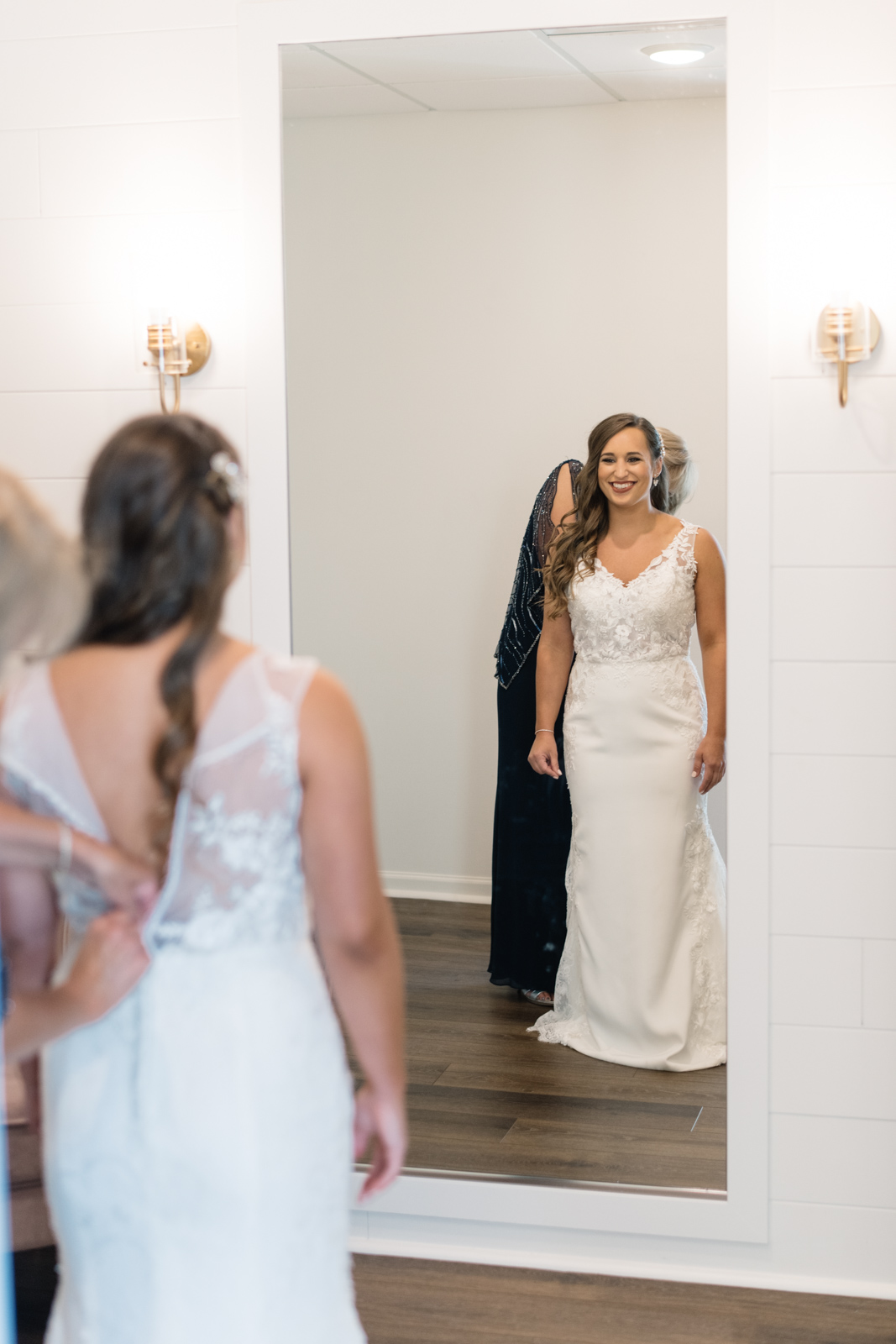 mom helping bride put on wedding dress bella sala in bridal suite bella sala wedding venue