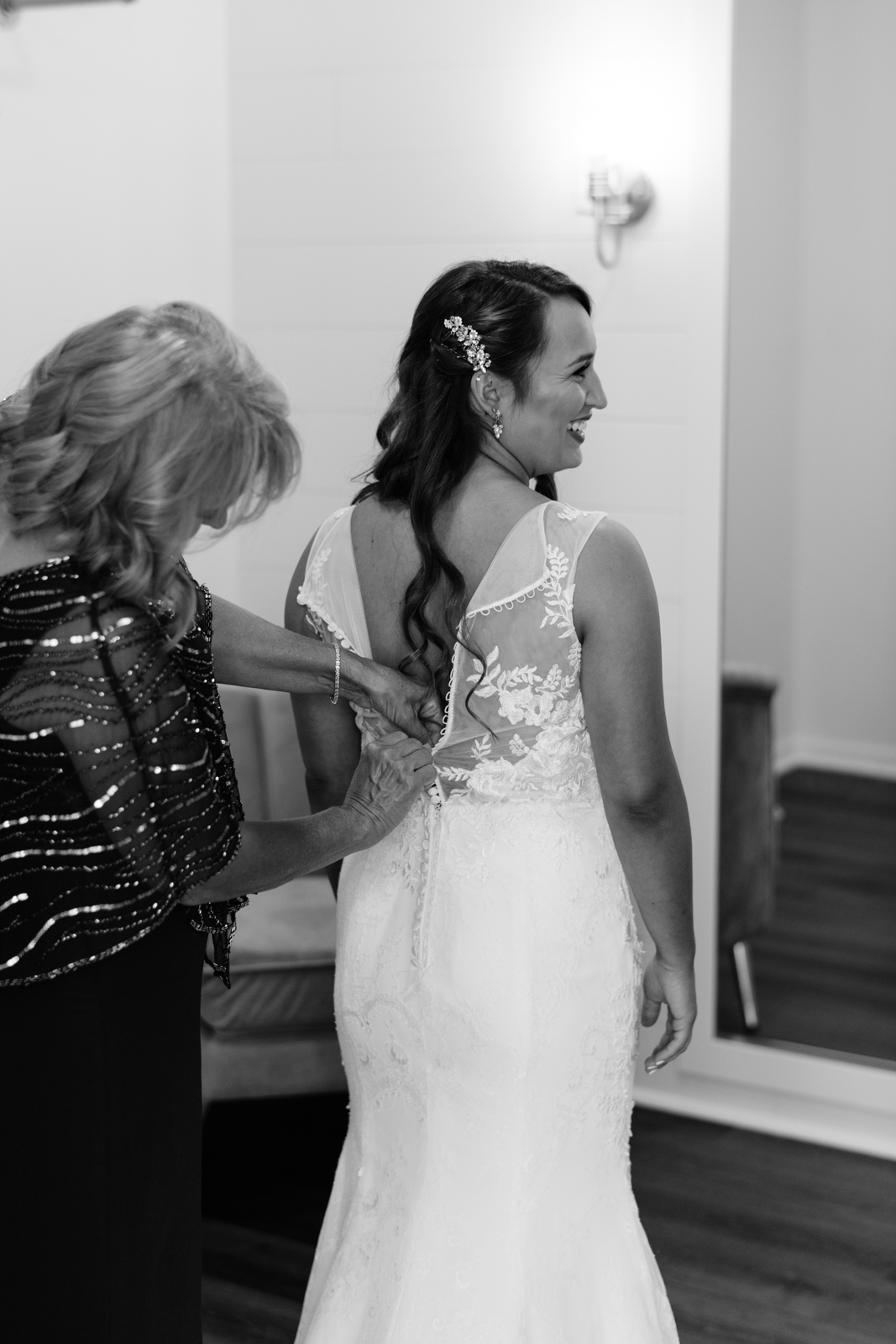mom helping bride put on wedding dress bella sala in bridal suite bella sala wedding venue