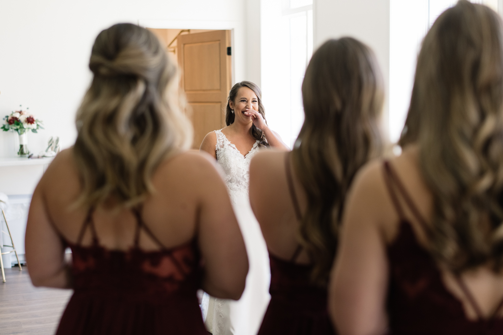 bride revealing wedding dress to bridesmaids during first look bella sala bridal suite