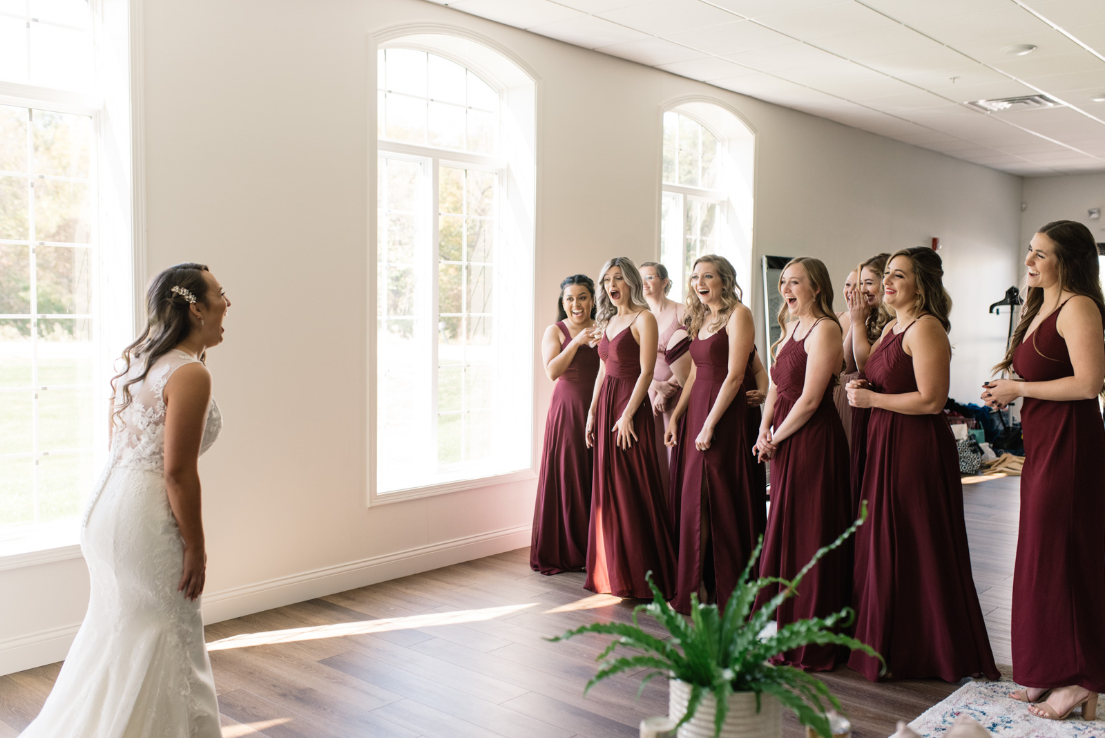 bride revealing wedding dress to bridesmaids during first look bella sala bridal suite