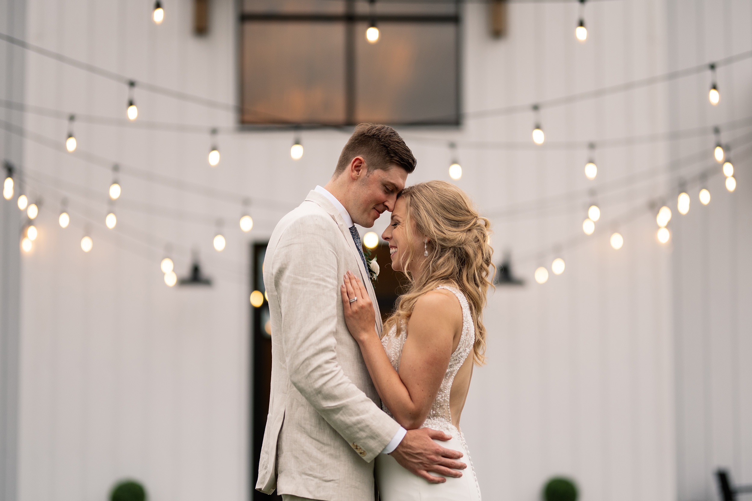 couple under twinkly light wedding arch brick wall olympic south side theater wedding venue cedar rapids