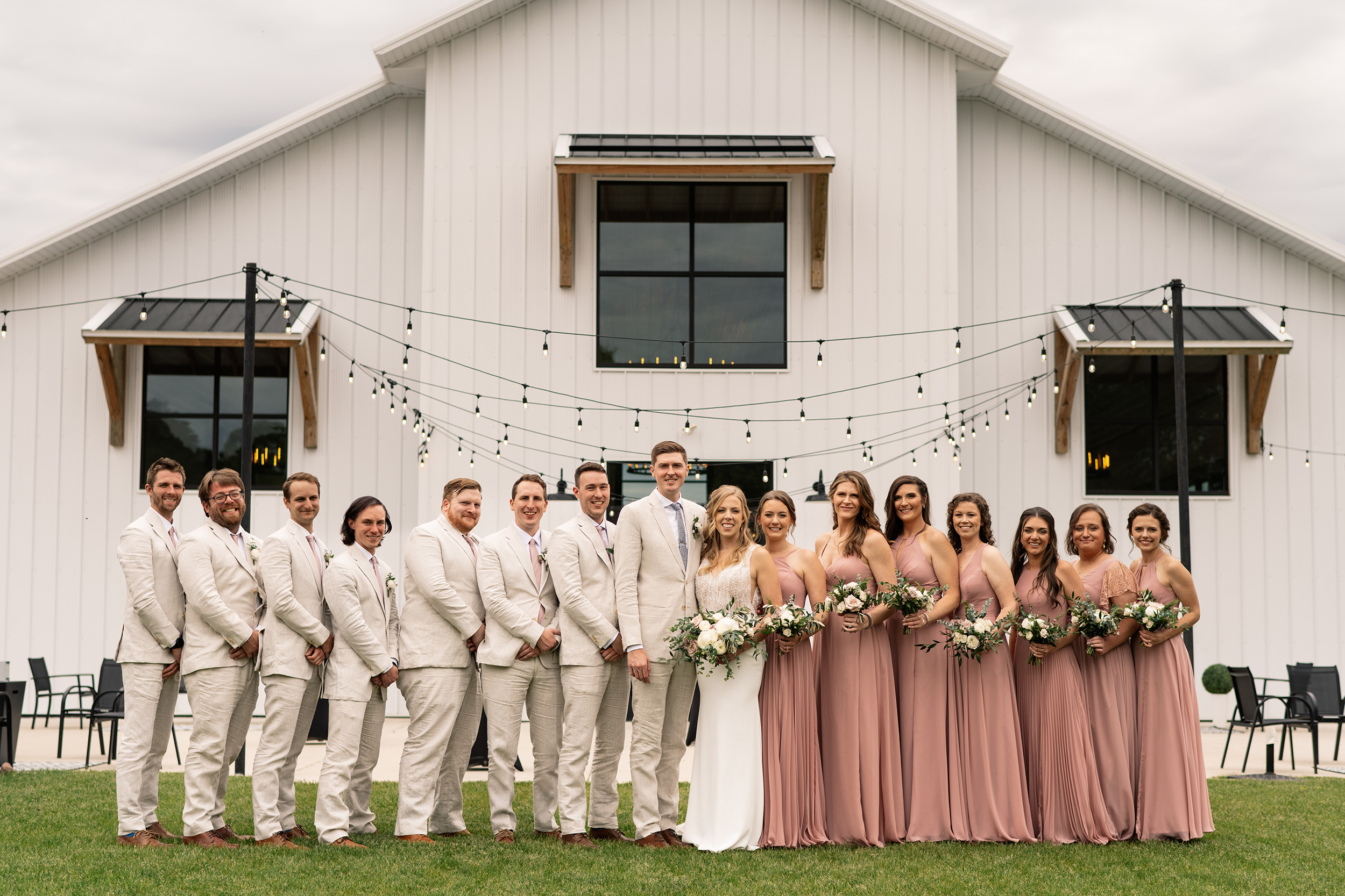 couple under twinkly light wedding arch brick wall olympic south side theater wedding venue cedar rapids